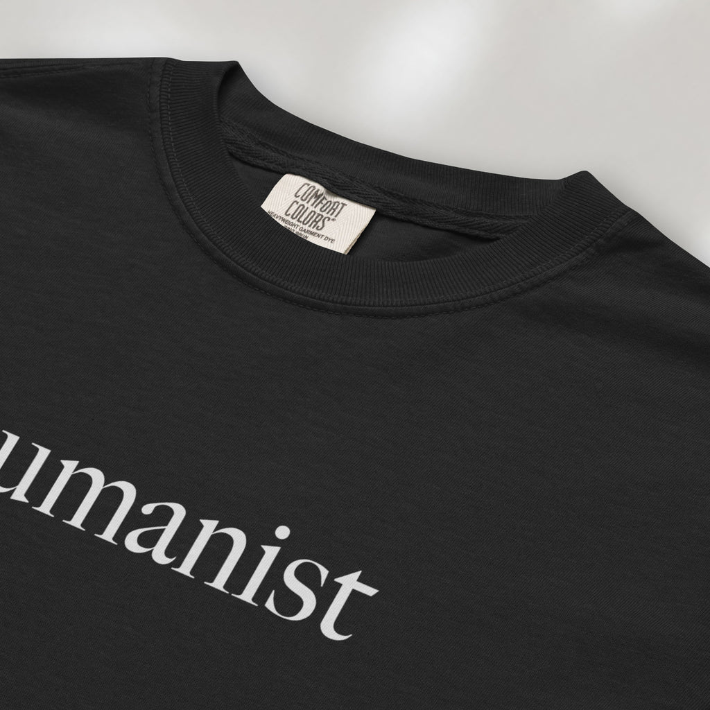 Closeup detail of black Comfort Colors t-shirt with minimalist serif text reading “humanist”.