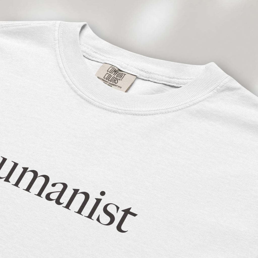 Closeup detail of white Comfort Colors t-shirt with minimalist serif text reading “humanist”.