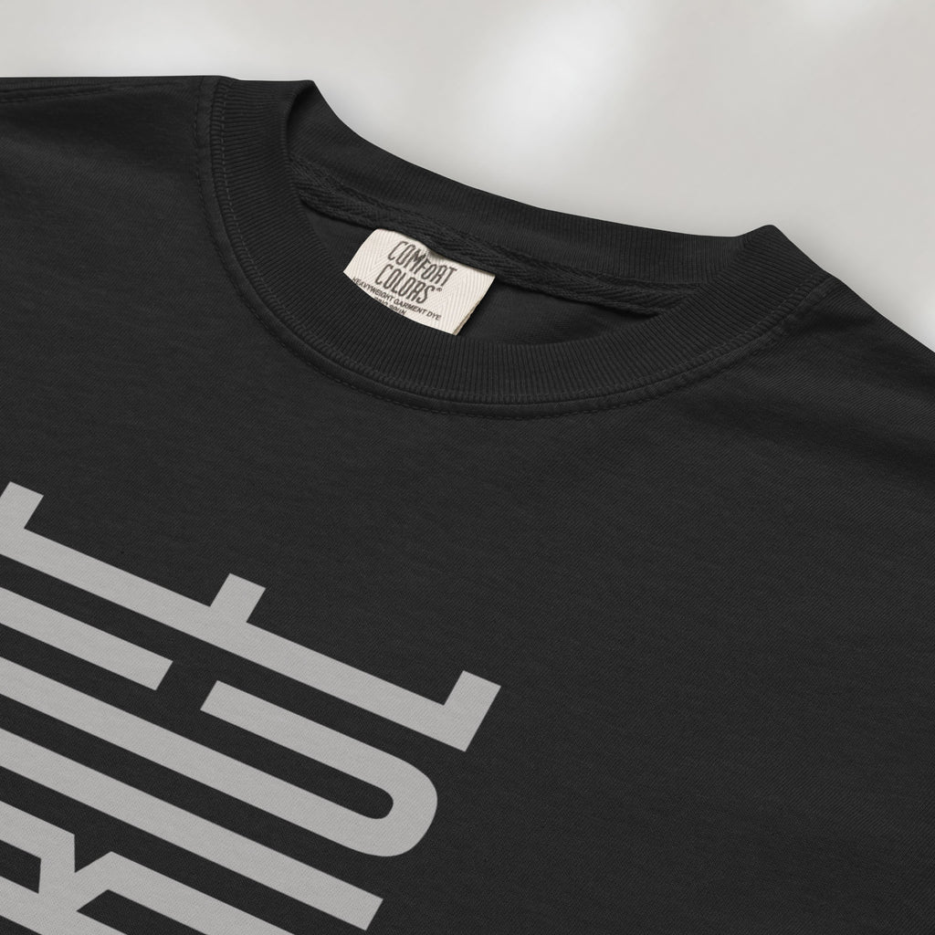 Closeup detail of black t-shirt with minimalist geometric design that subtly spells “Fuck ICE” using stacked bars and negative space, hidden protest message shirt.