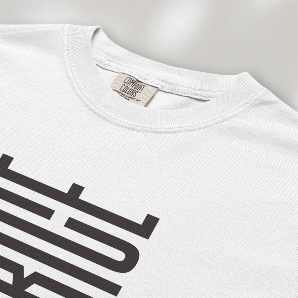 Closeup detail of white t-shirt with minimalist geometric design that subtly spells “Fuck ICE” using stacked bars and negative space, hidden protest message shirt.