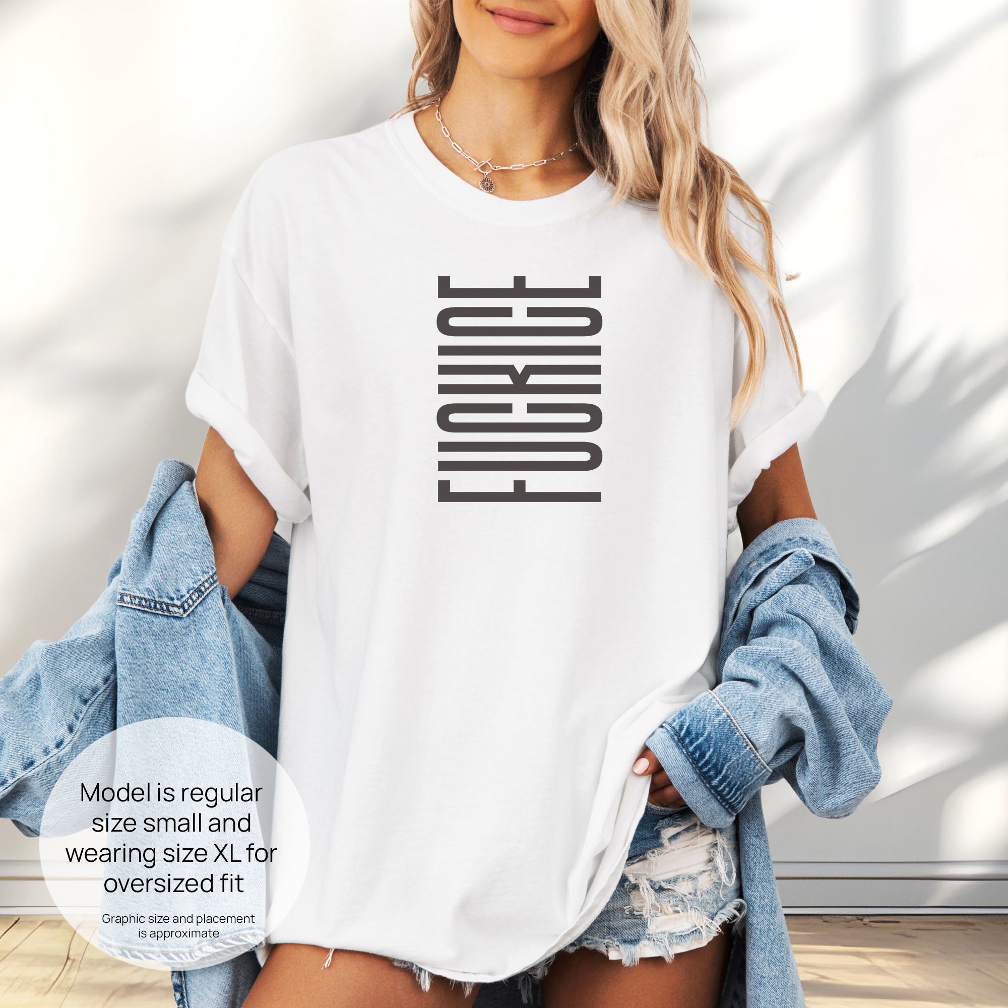 Female model wearing oversized white t-shirt with minimalist geometric design that subtly spells “Fuck ICE” using stacked bars and negative space, hidden protest message shirt. Includes size and fit information for the model who is regular size small, and wearing a size XL shirt for an oversized fit.
