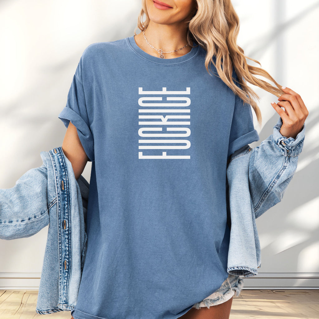 Female model wearing oversized blue jean t-shirt with minimalist geometric design that subtly spells “Fuck ICE” using stacked bars and negative space, hidden protest message shirt.