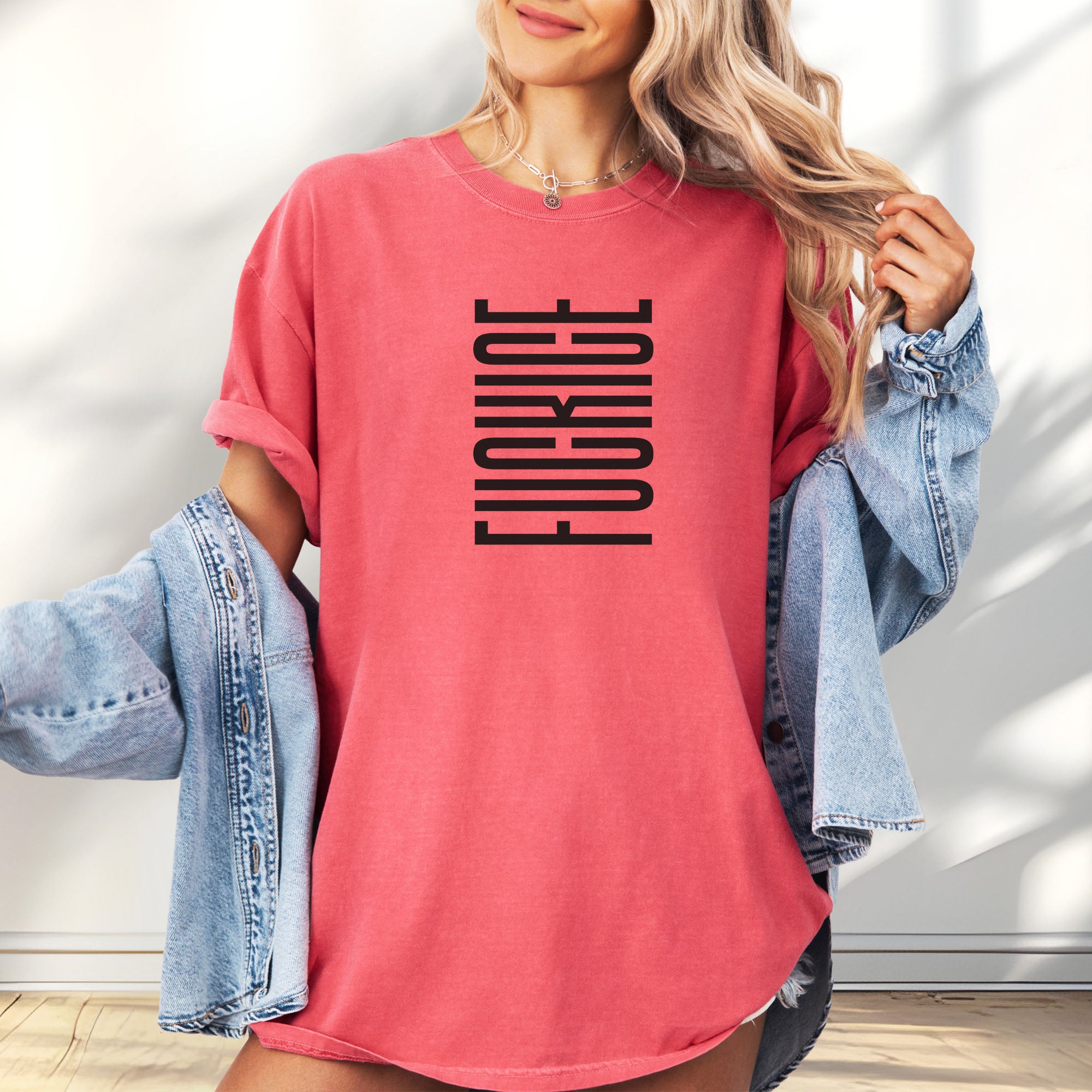 Female model wearing oversized watermelon t-shirt with minimalist black geometric design that subtly spells “Fuck ICE” using stacked bars and negative space, hidden protest message shirt.