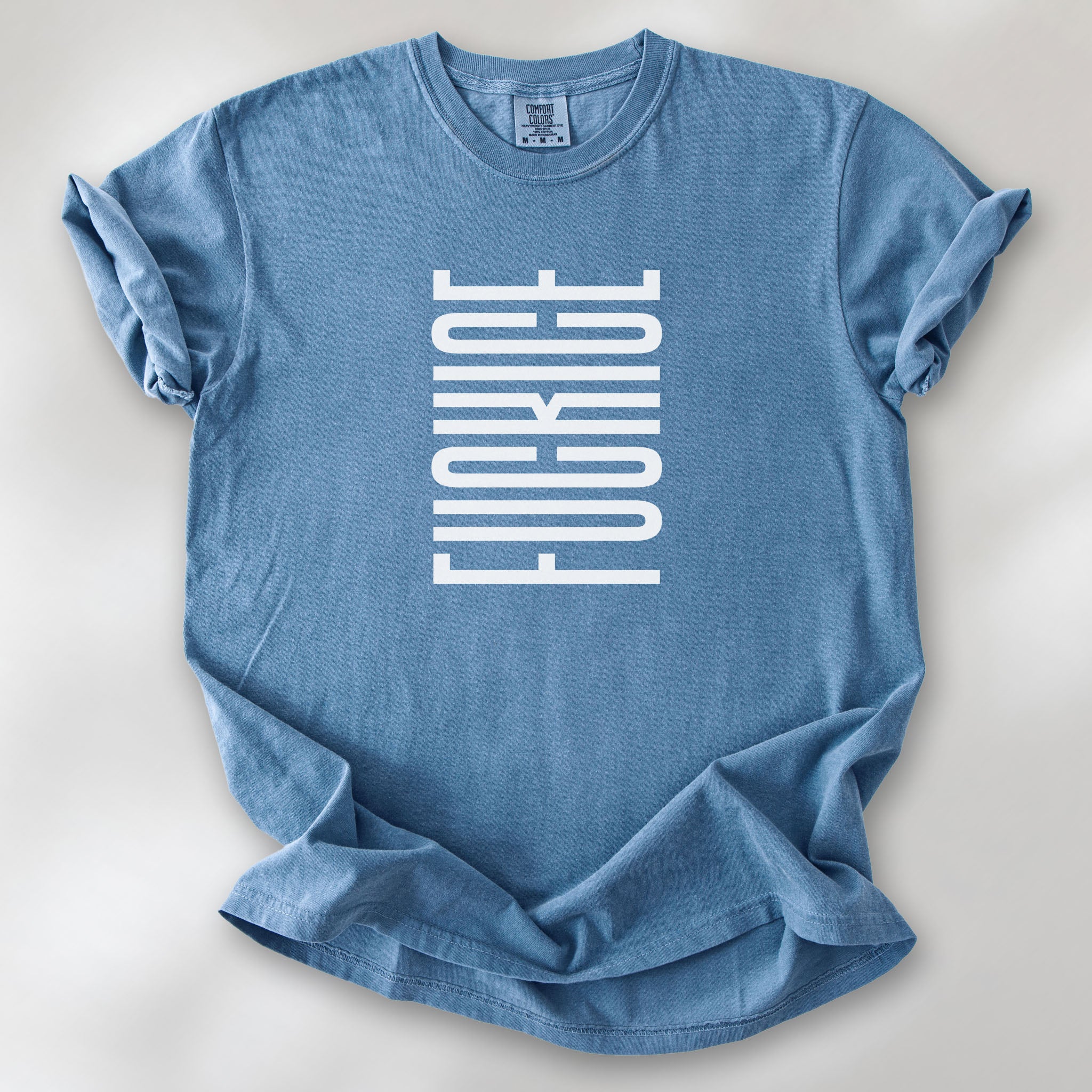 Blue jean t-shirt with minimalist geometric design that subtly spells “Fuck ICE” using stacked bars and negative space, hidden protest message shirt.