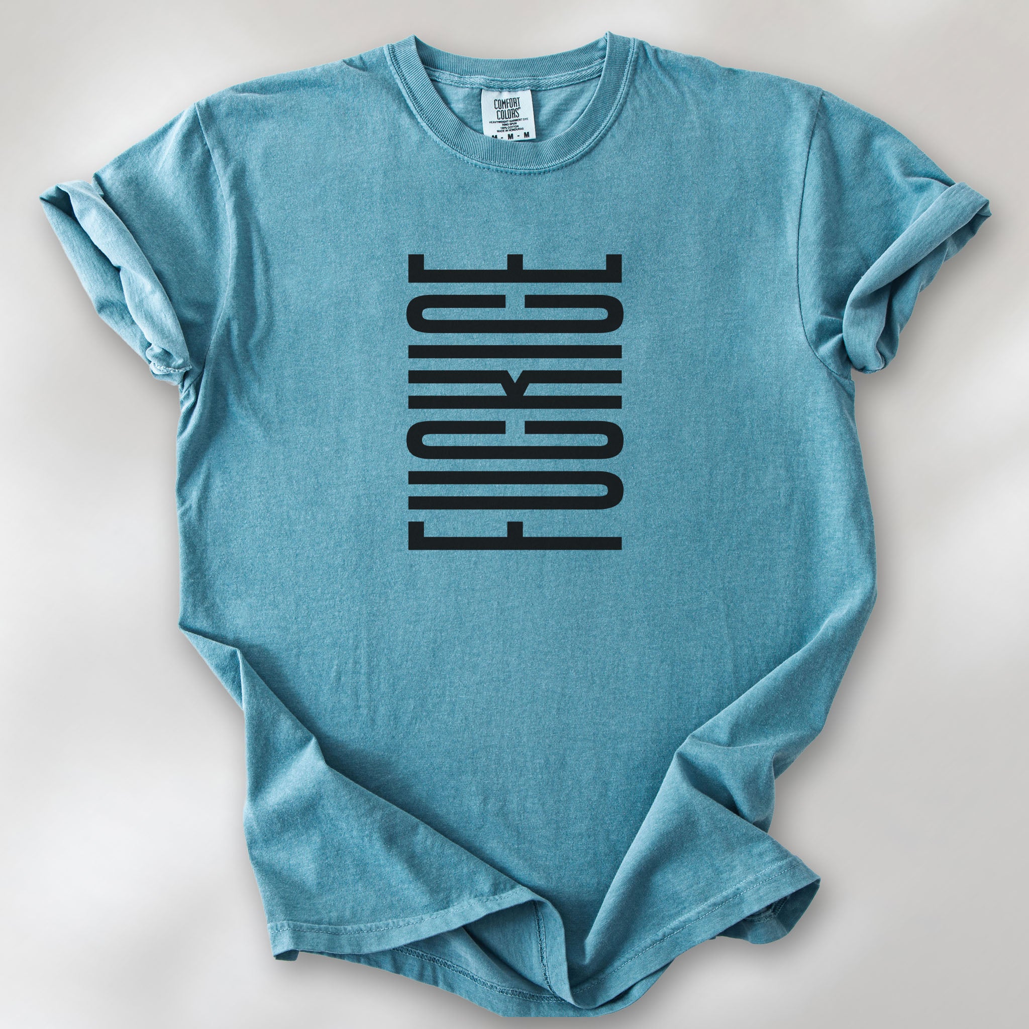 Ice blue t-shirt with minimalist black geometric design that subtly spells “Fuck ICE” using stacked bars and negative space, hidden protest message shirt.