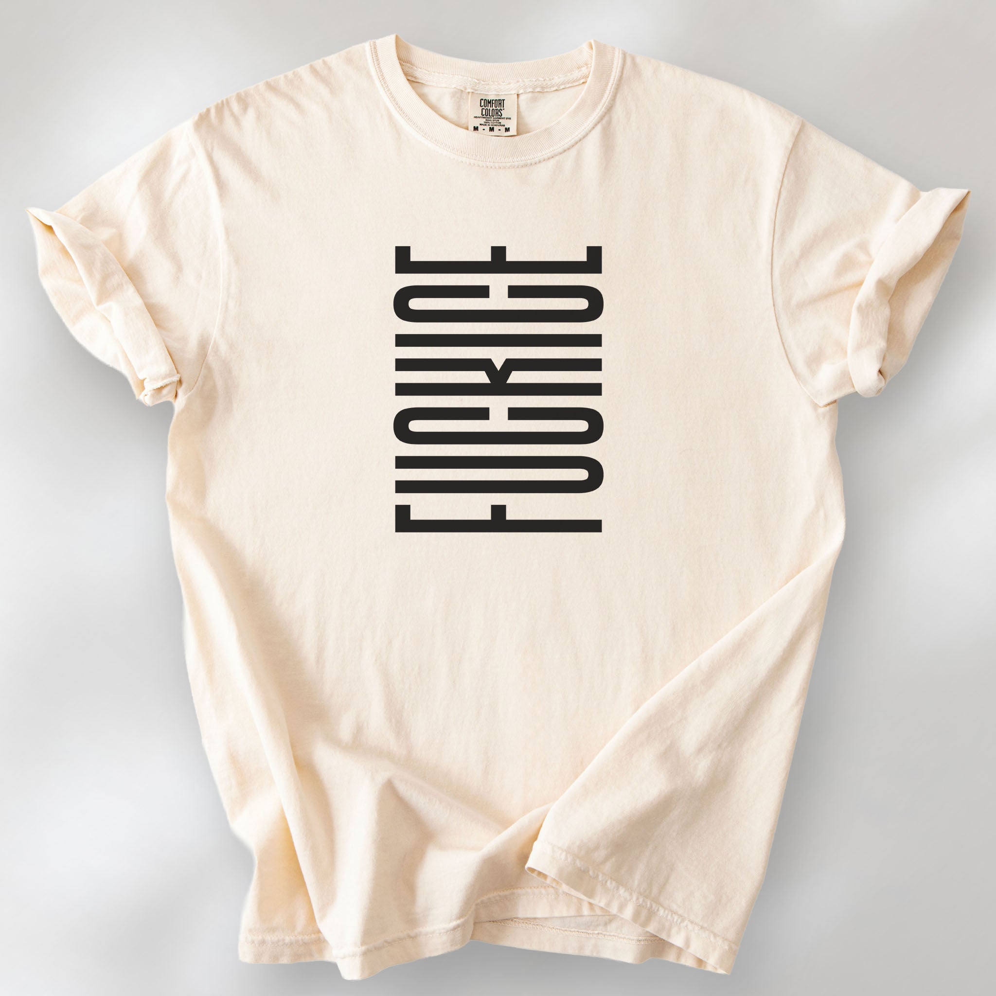 Ivory t-shirt with minimalist black geometric design that subtly spells “Fuck ICE” using stacked bars and negative space, hidden protest message shirt.