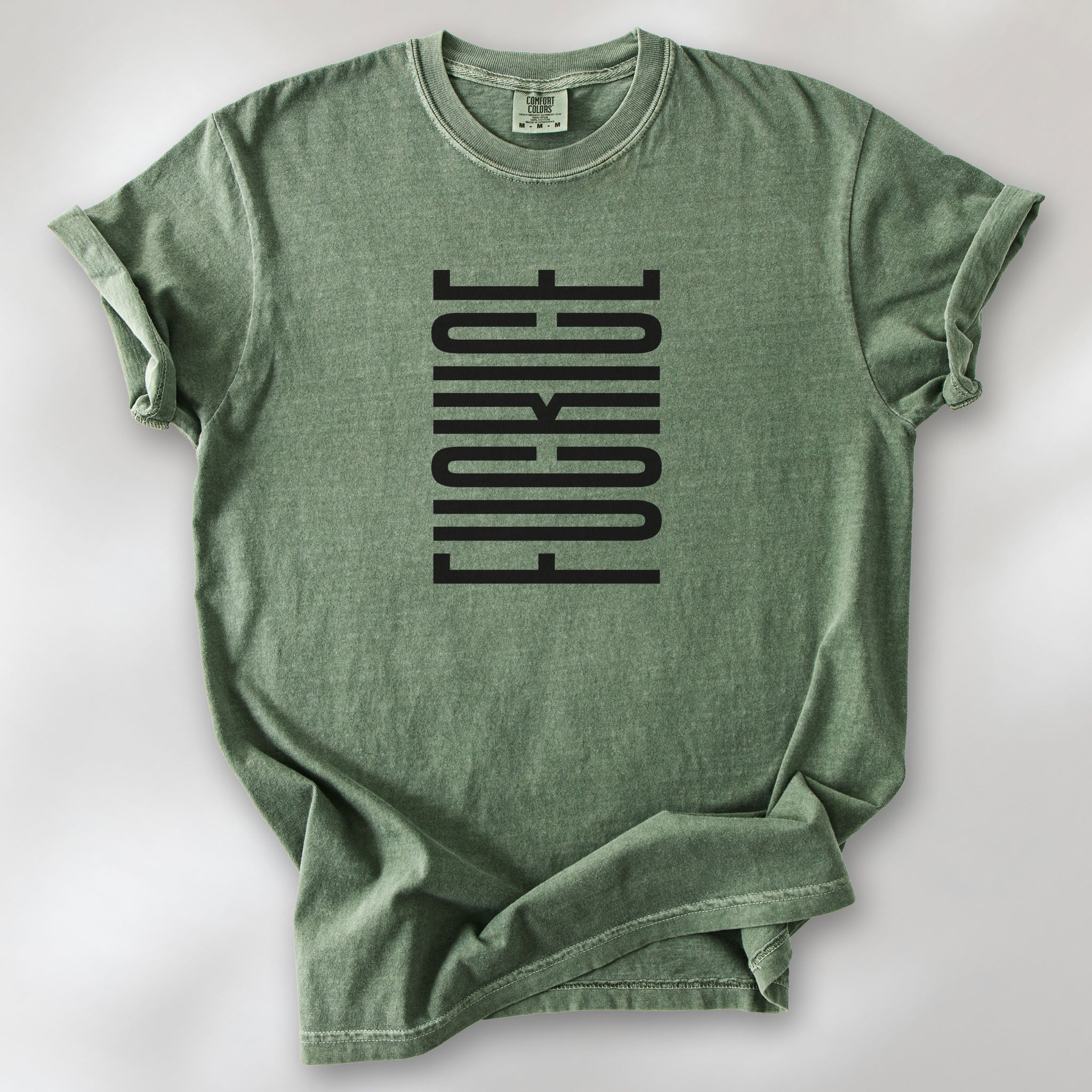 Moss t-shirt with minimalist black geometric design that subtly spells “Fuck ICE” using stacked bars and negative space, hidden protest message shirt.