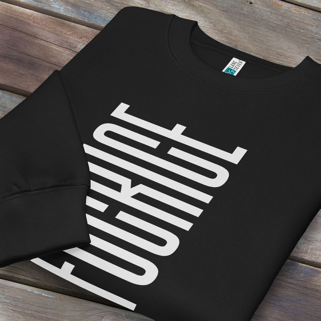 Folded black sweatshirt with minimalist black geometric design that subtly spells “Fuck ICE” using stacked bars and negative space, hidden protest message shirt.