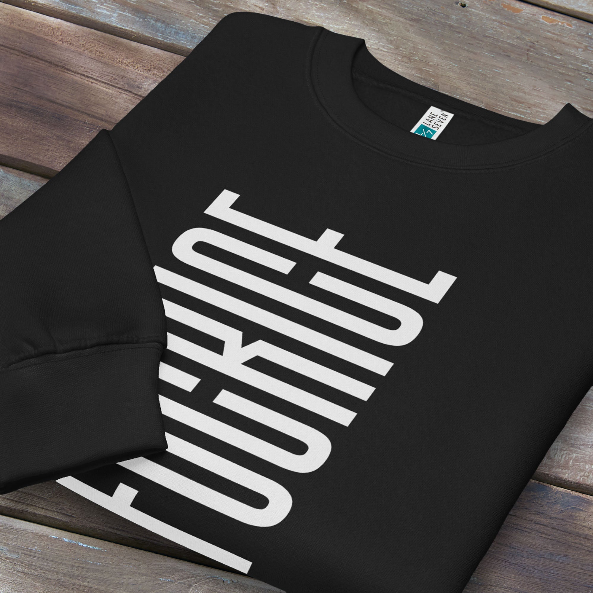 Folded black sweatshirt with minimalist black geometric design that subtly spells “Fuck ICE” using stacked bars and negative space, hidden protest message shirt.