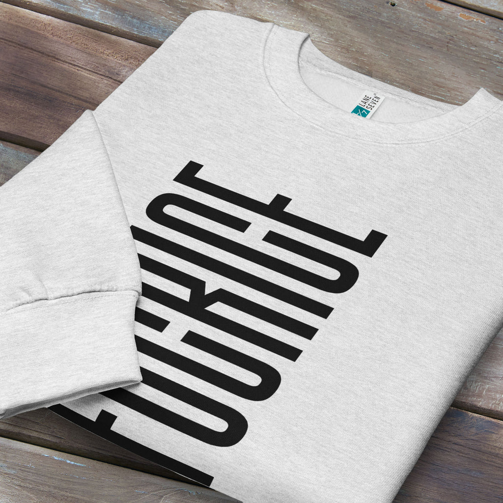 Folded grey sweatshirt with minimalist black geometric design that subtly spells “Fuck ICE” using stacked bars and negative space, hidden protest message shirt.