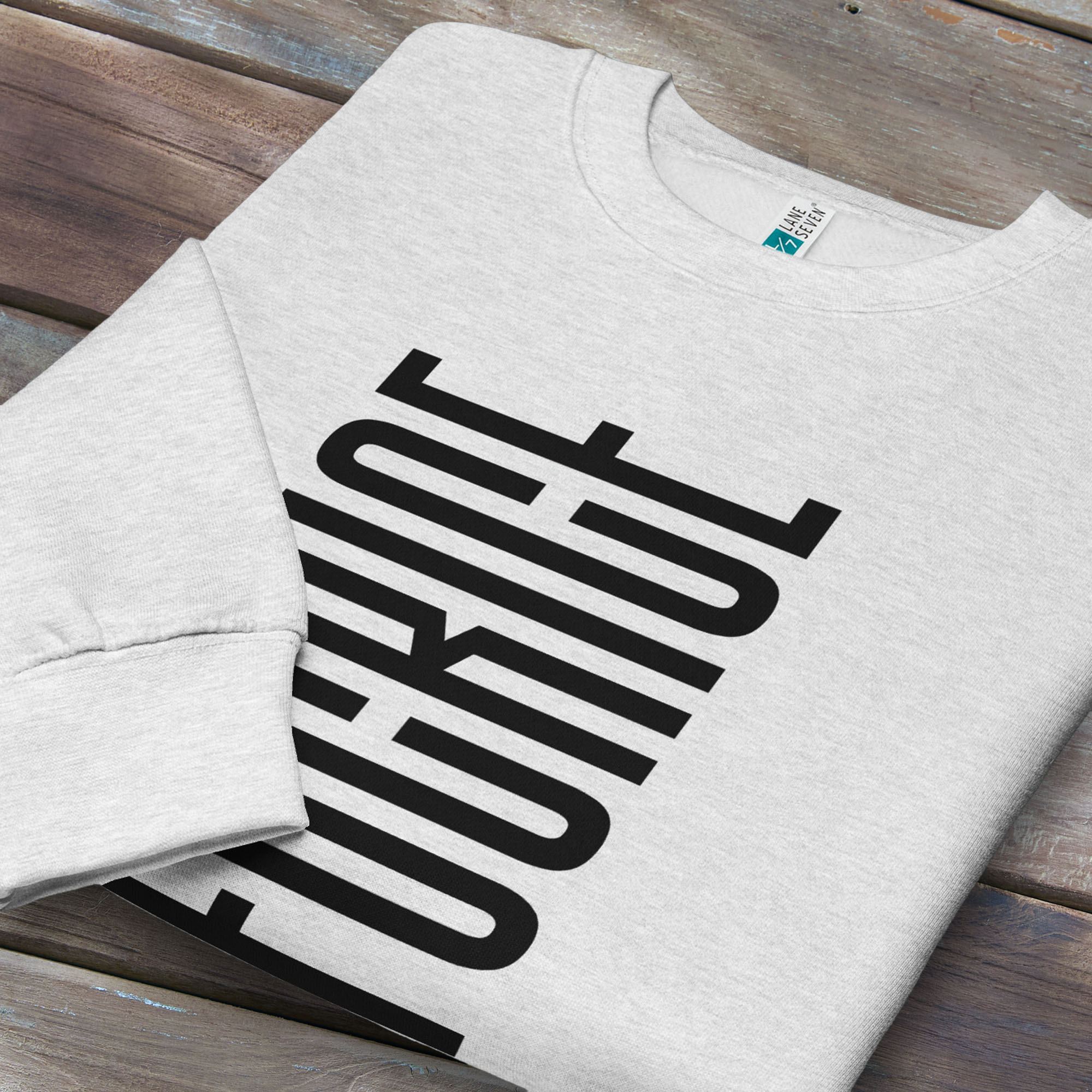 Folded grey sweatshirt with minimalist black geometric design that subtly spells “Fuck ICE” using stacked bars and negative space, hidden protest message shirt.