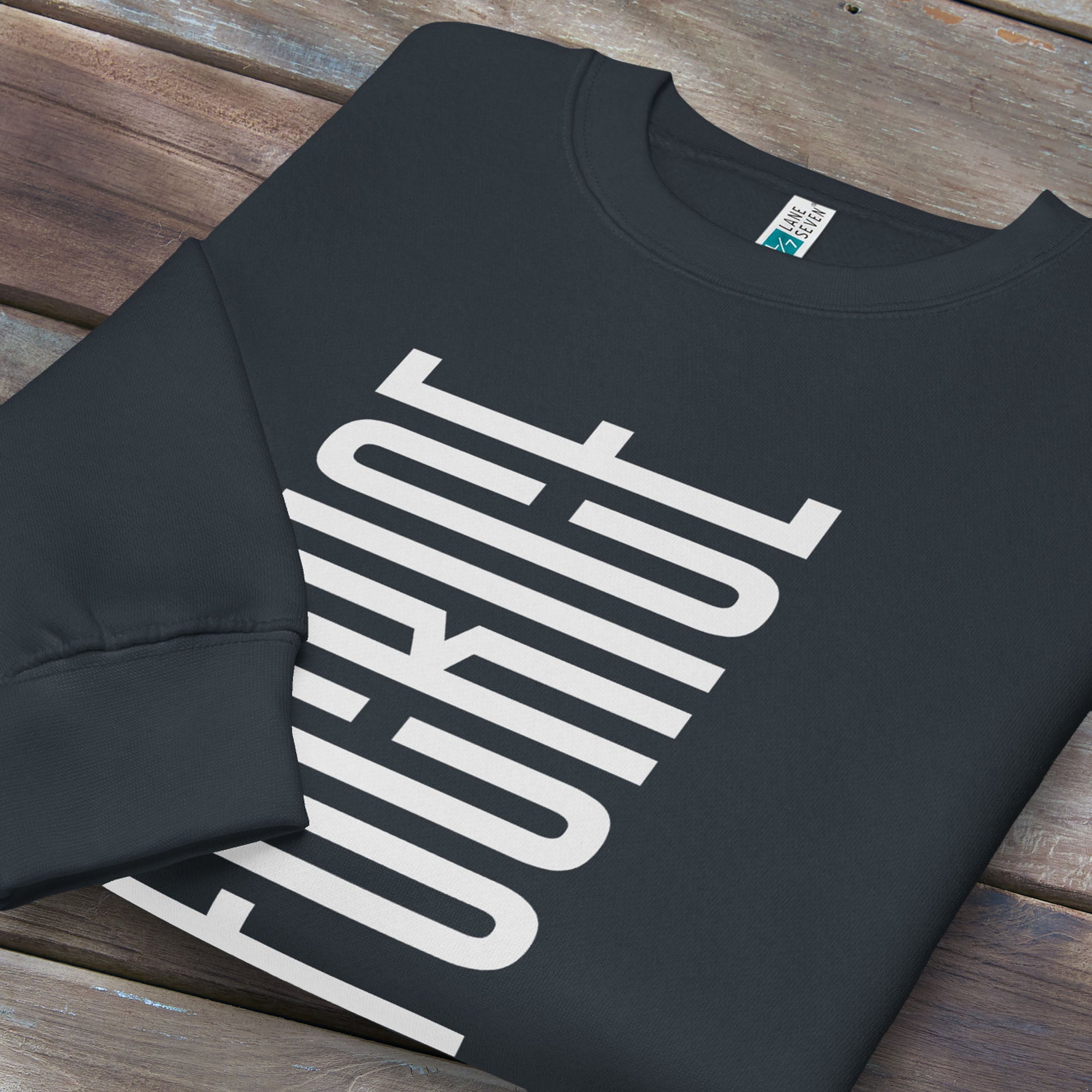 Folded navy sweatshirt with minimalist black geometric design that subtly spells “Fuck ICE” using stacked bars and negative space, hidden protest message shirt.