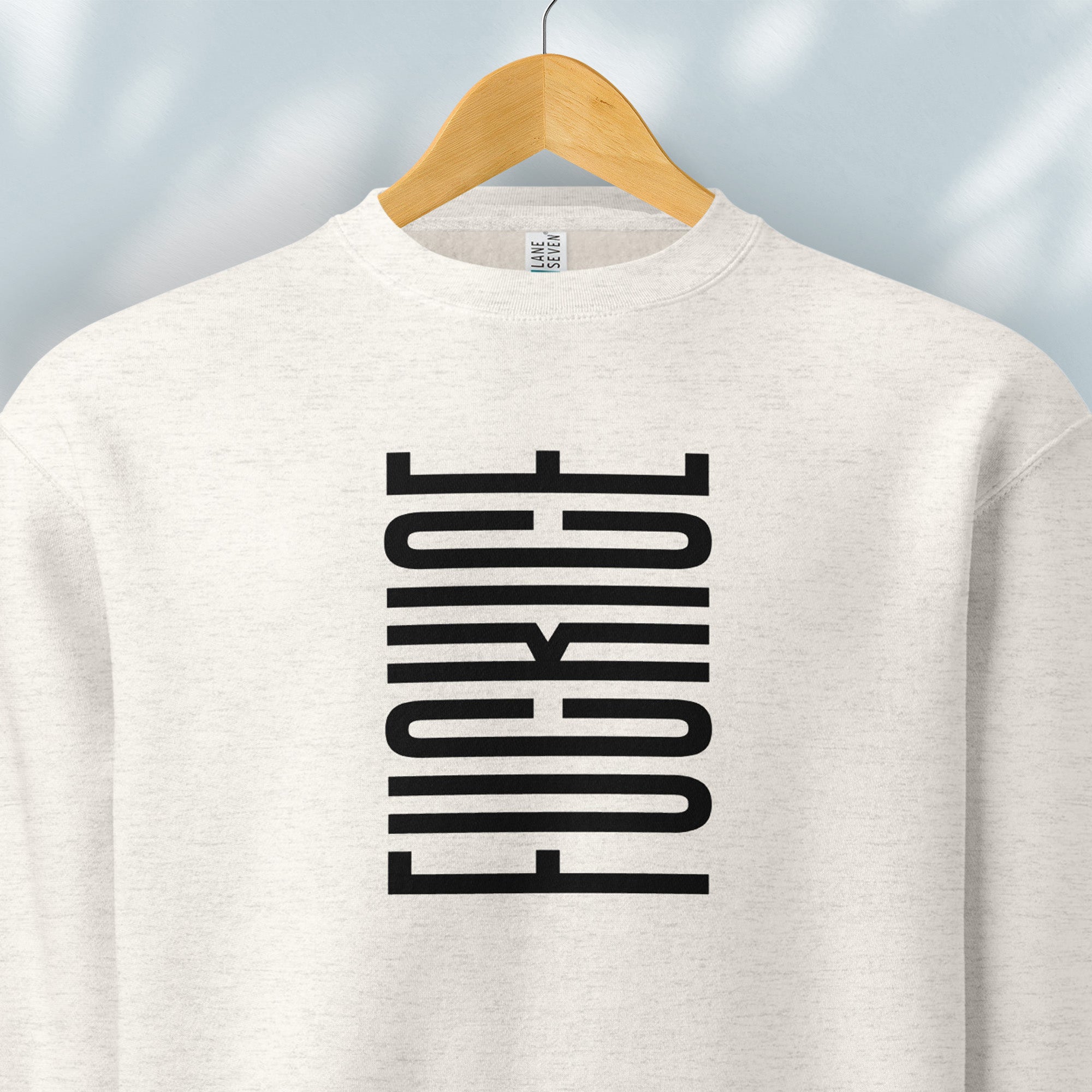 Hanging oatmeal sweatshirt with minimalist black geometric design that subtly spells “Fuck ICE” using stacked bars and negative space, hidden protest message shirt.