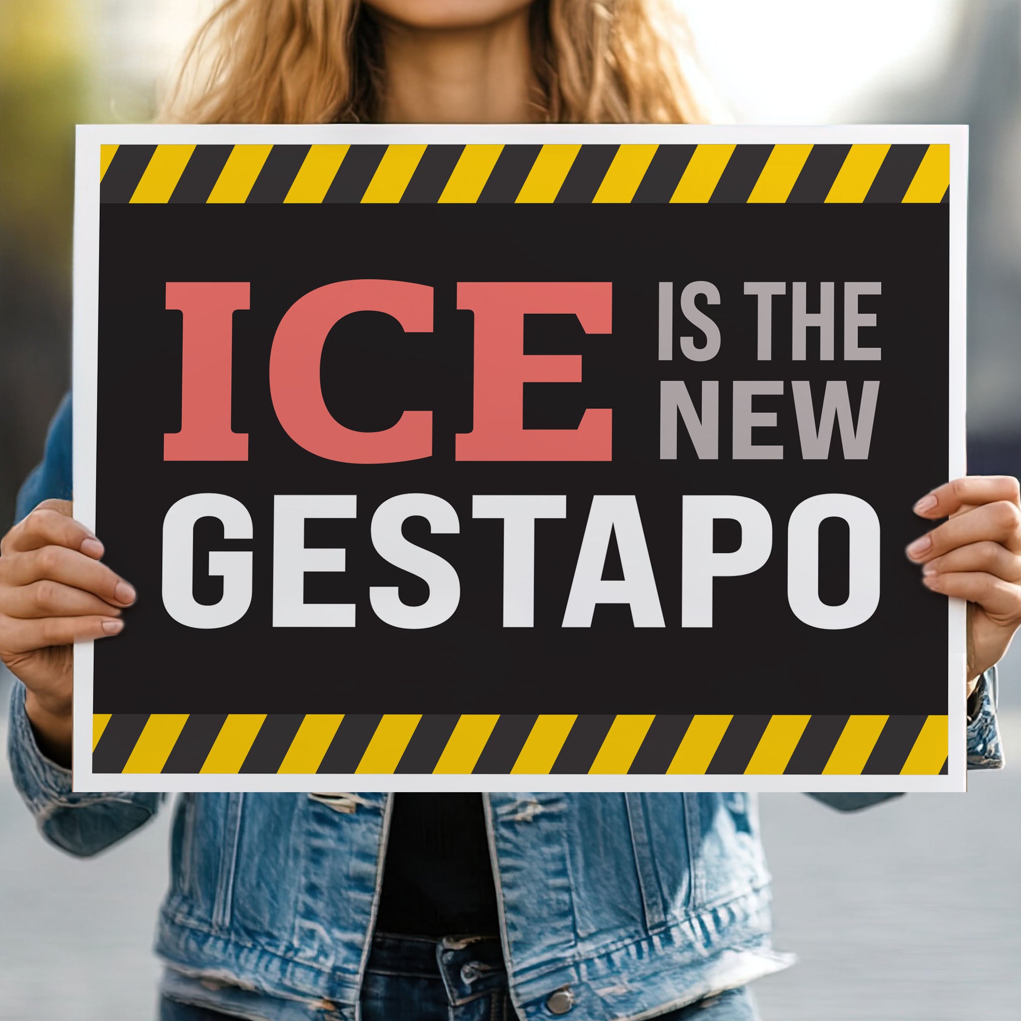 Person holding protest sign that reads "ICE is the new gestapo" in strong bold red, grey, and white text on a black background with yellow warning stripes at the top and bottom.