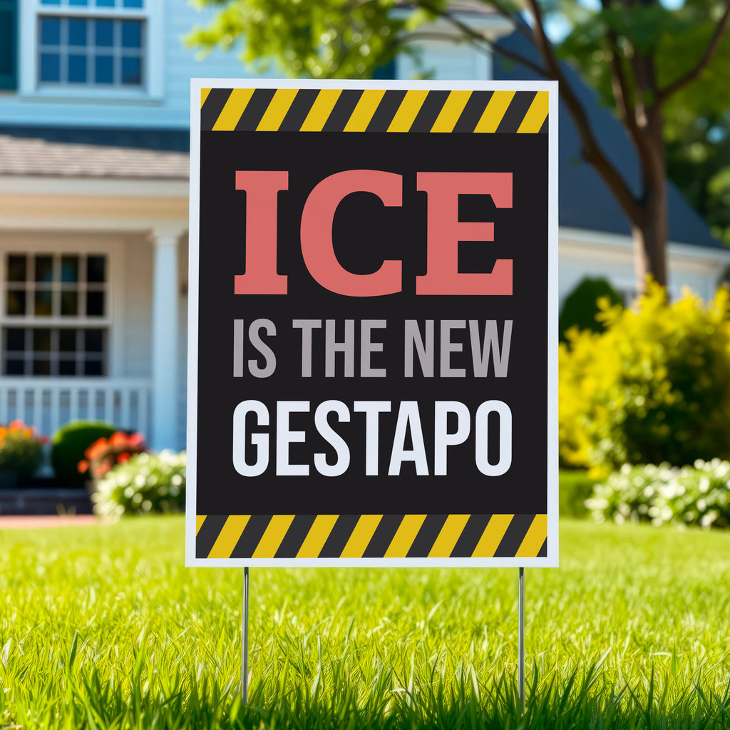 Yard sign in green lawn that reads "ICE is the new gestapo" in strong bold red, grey, and white text on a black background with yellow warning stripes at the top and bottom.