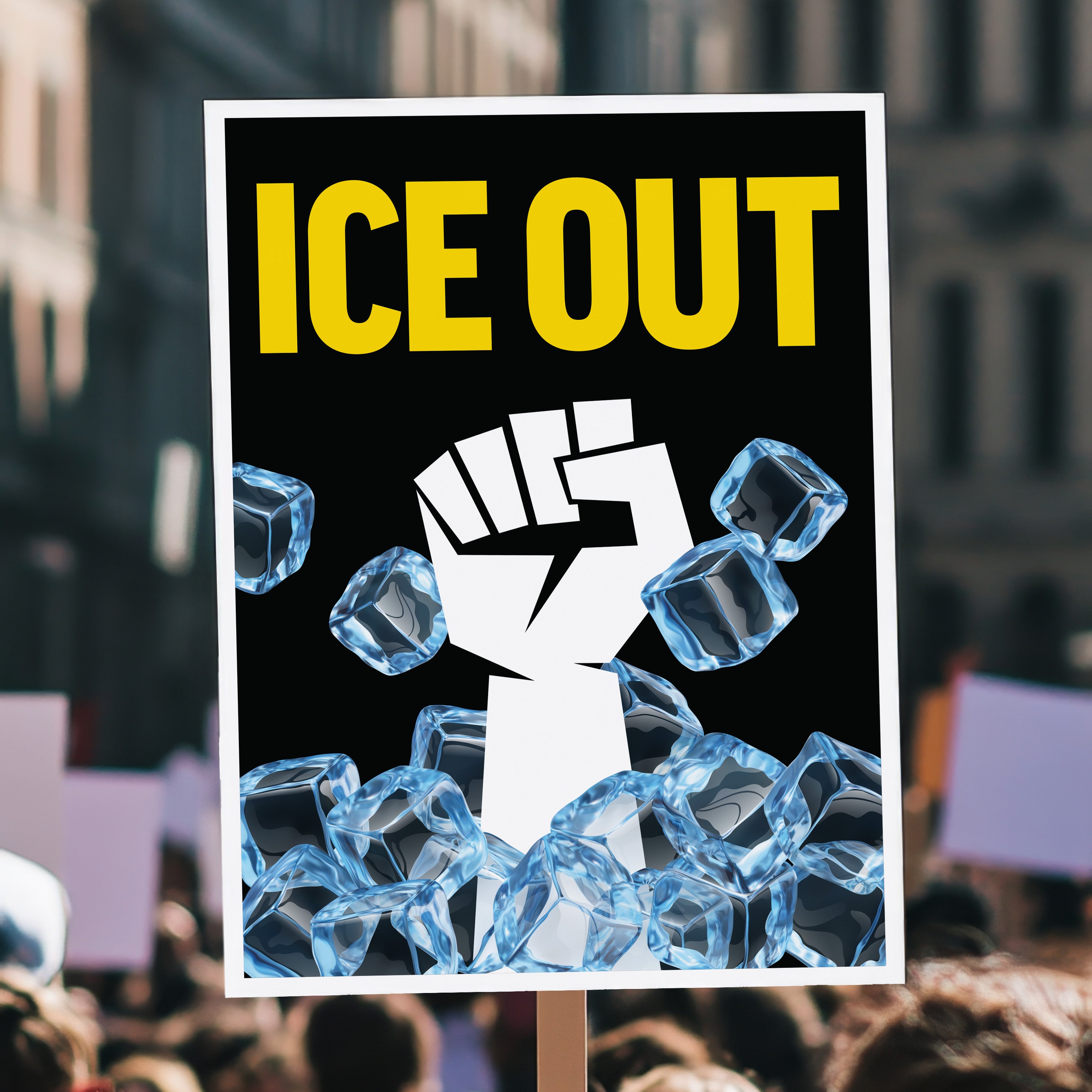 Protest sign held high above a crowd that reads “ice out” in yellow text above a white raised fist breaking through blue ice cubes on a black background.