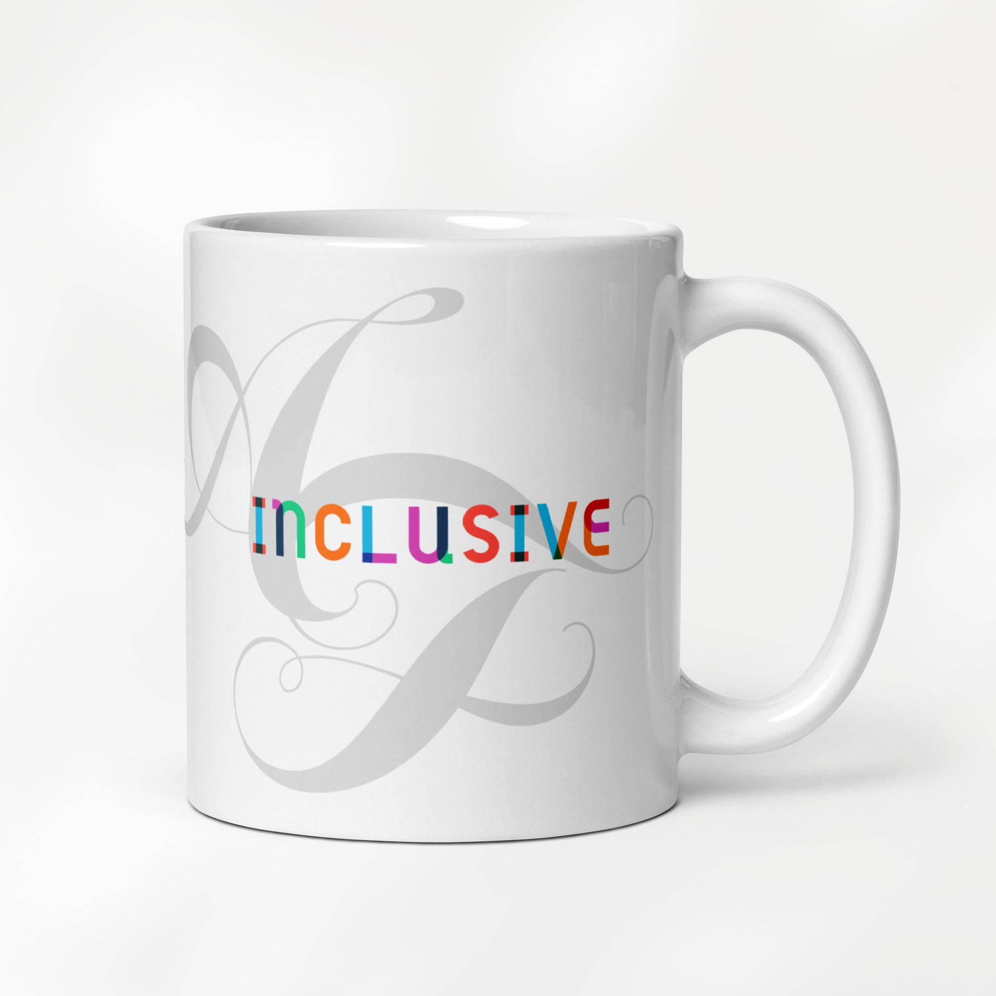 11 ounce white ceramic mug with the word “Inclusive” in colorful Gilbert font and faint script letters A and F behind it.