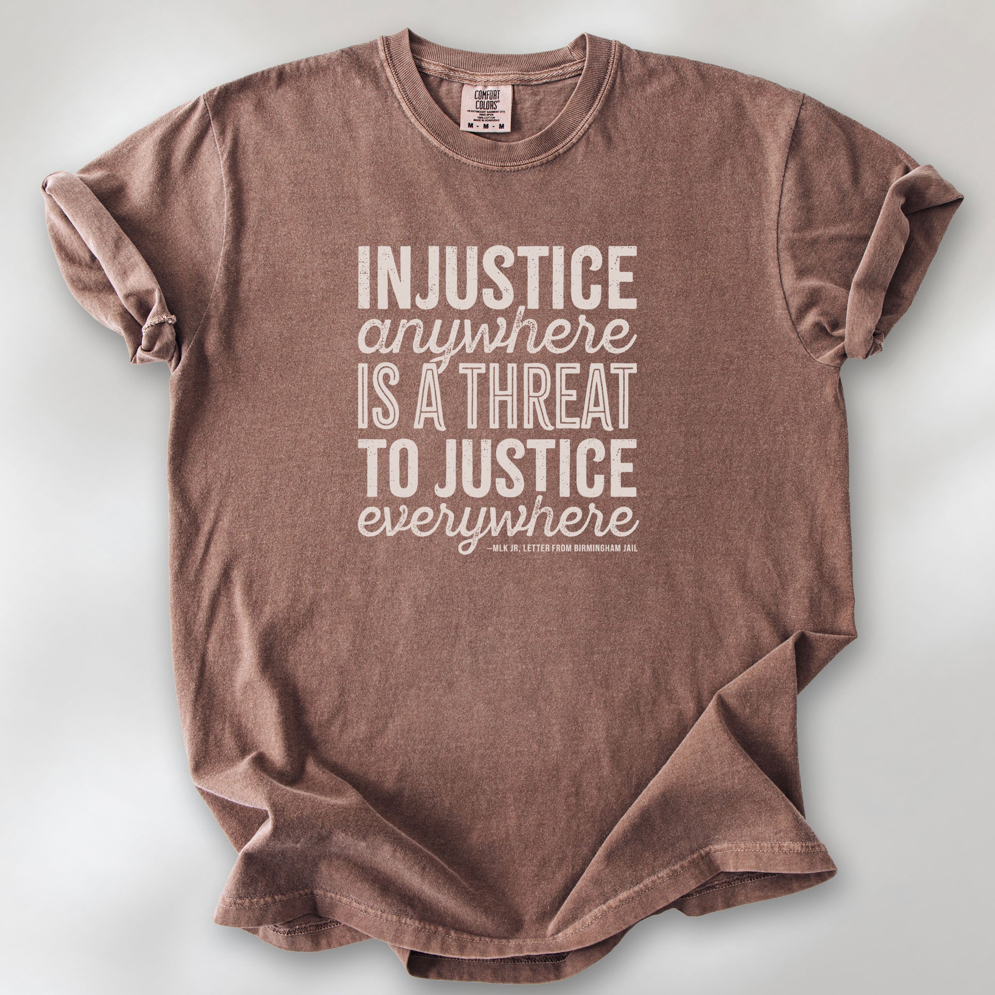 Espresso t-shirt with bold text reading “Injustice anywhere is a threat to justice everywhere” quote from Martin Luther King Jr, MLK Jr, Letter from Birmingham jail — civil rights protest apparel for activists.