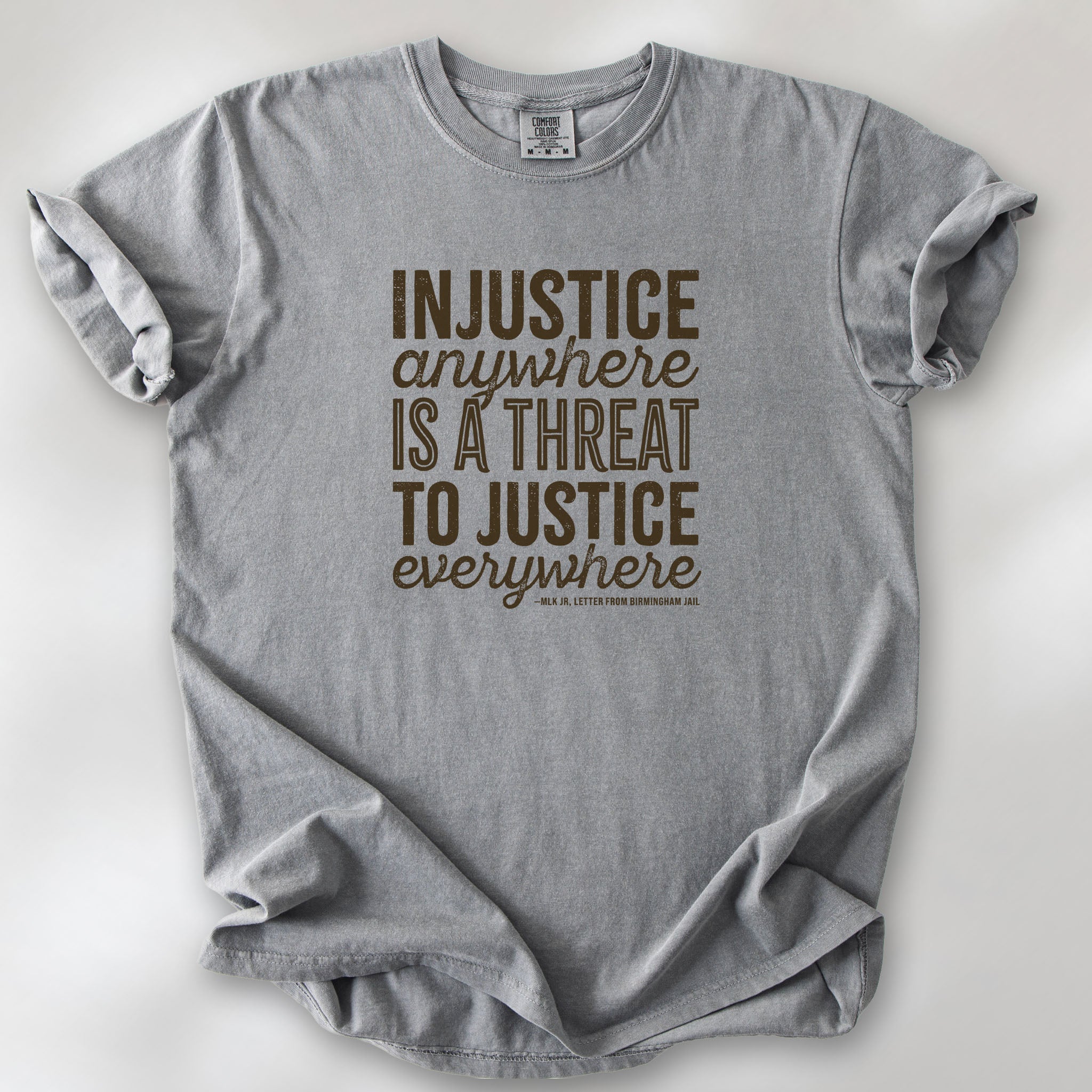 Grey t-shirt with bold text reading “Injustice anywhere is a threat to justice everywhere” quote from Martin Luther King Jr, MLK Jr, Letter from Birmingham jail — civil rights protest apparel for activists.