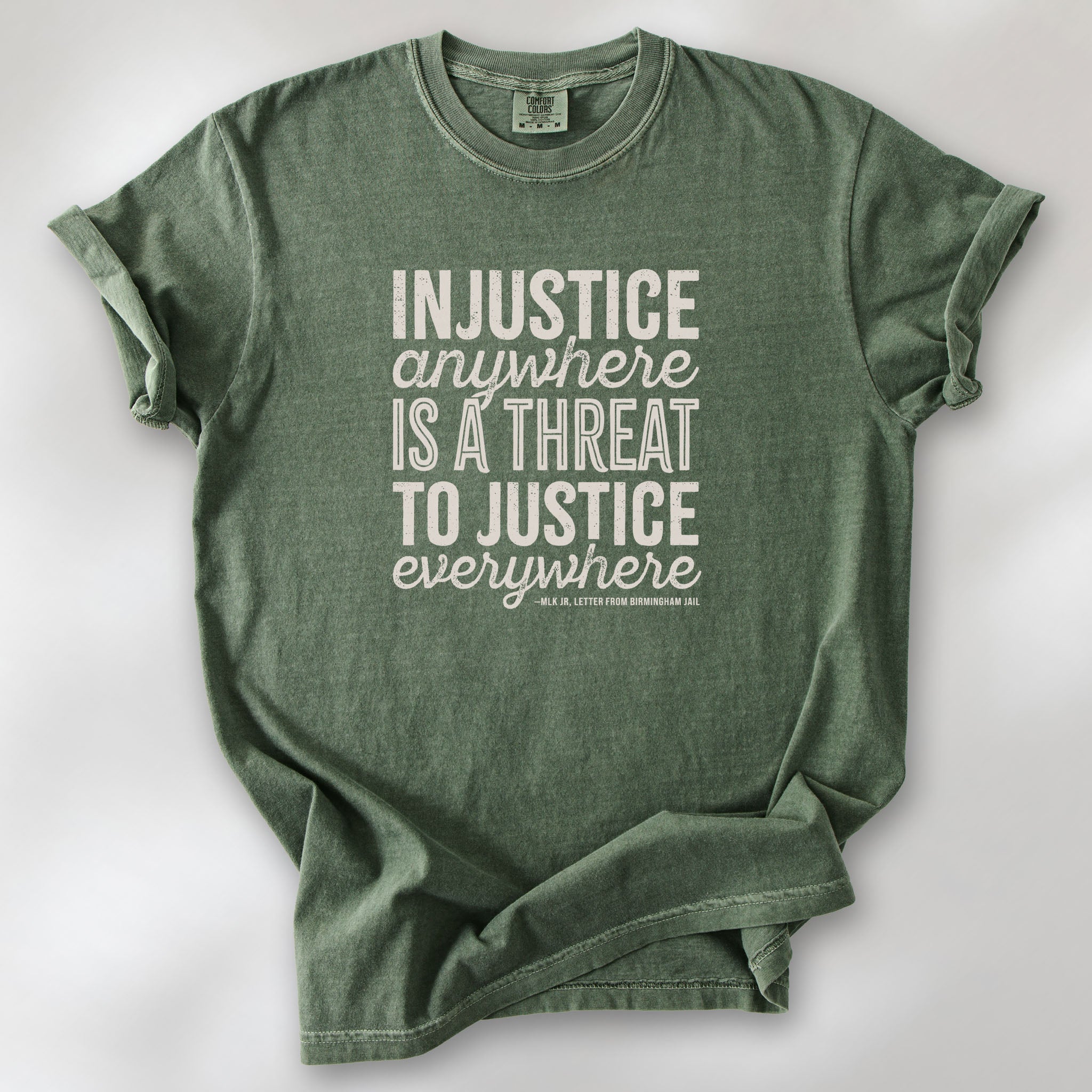  Moss t-shirt with bold text reading “Injustice anywhere is a threat to justice everywhere” quote from Martin Luther King Jr, MLK Jr, Letter from Birmingham jail — civil rights protest apparel for activists.