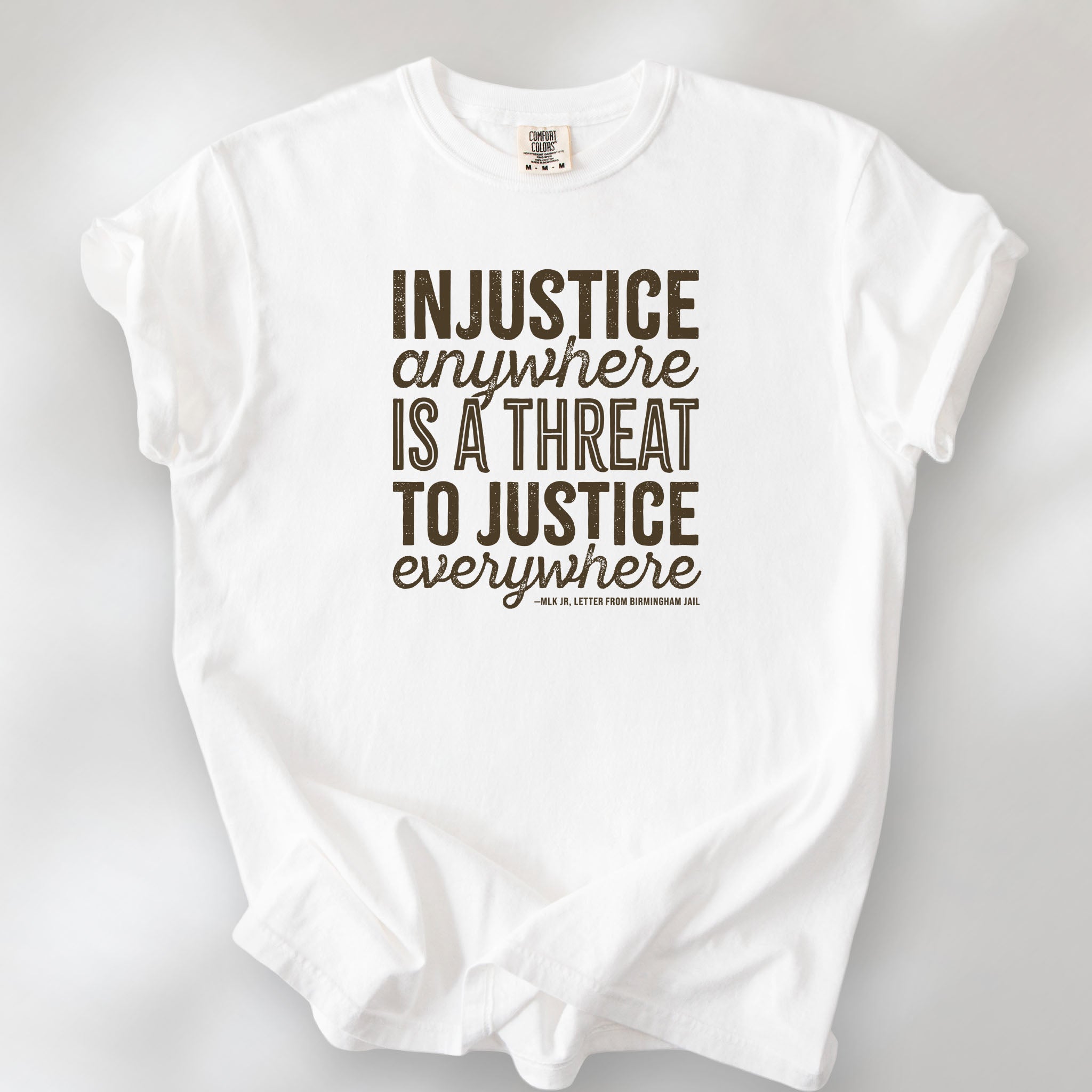 White t-shirt with bold text reading “Injustice anywhere is a threat to justice everywhere” quote from Martin Luther King Jr, MLK Jr, Letter from Birmingham jail — civil rights protest apparel for activists.