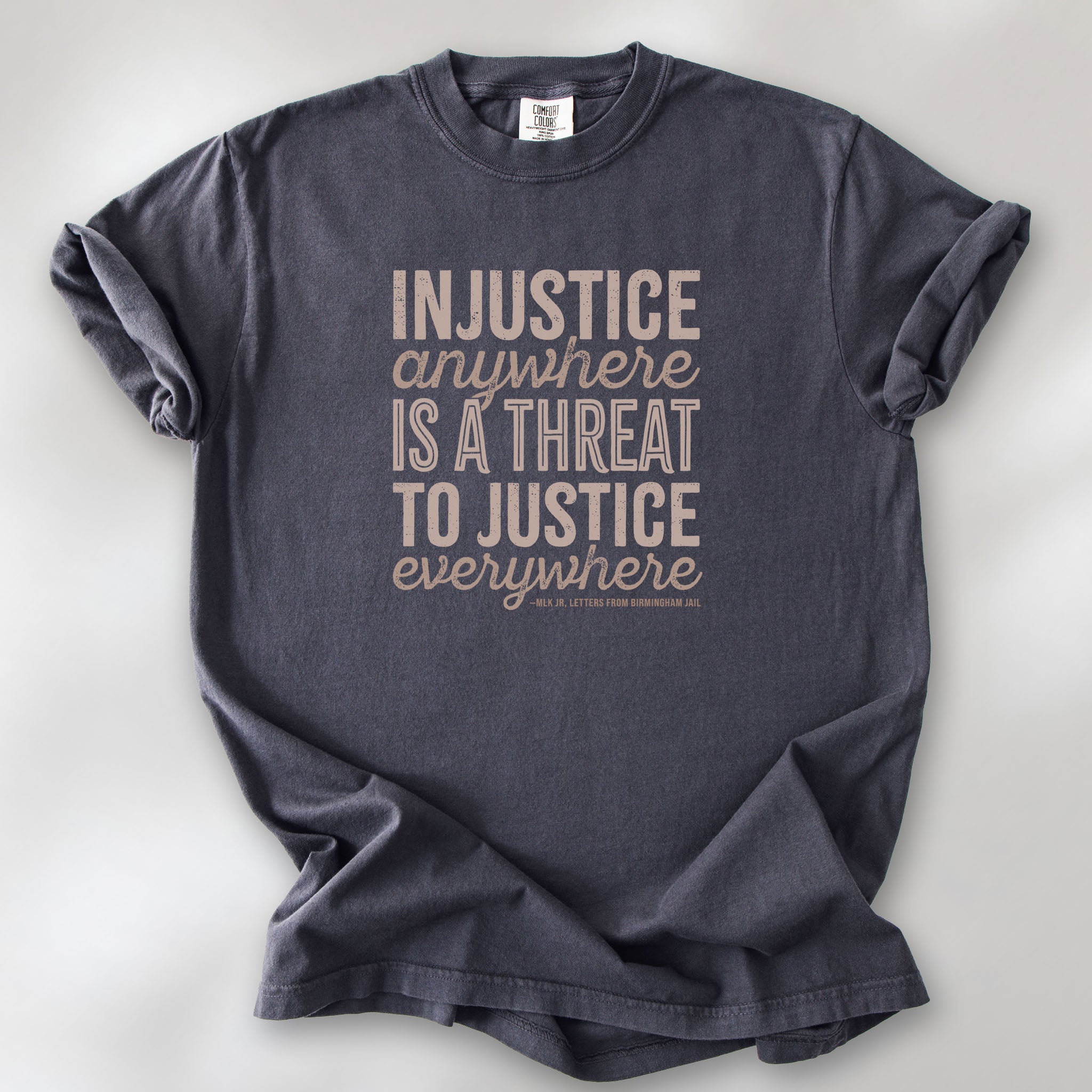 Graphite t-shirt with bold text reading “Injustice anywhere is a threat to justice everywhere” quote from Martin Luther King Jr, MLK Jr, Letters from Birmingham jail — civil rights protest apparel for activists.