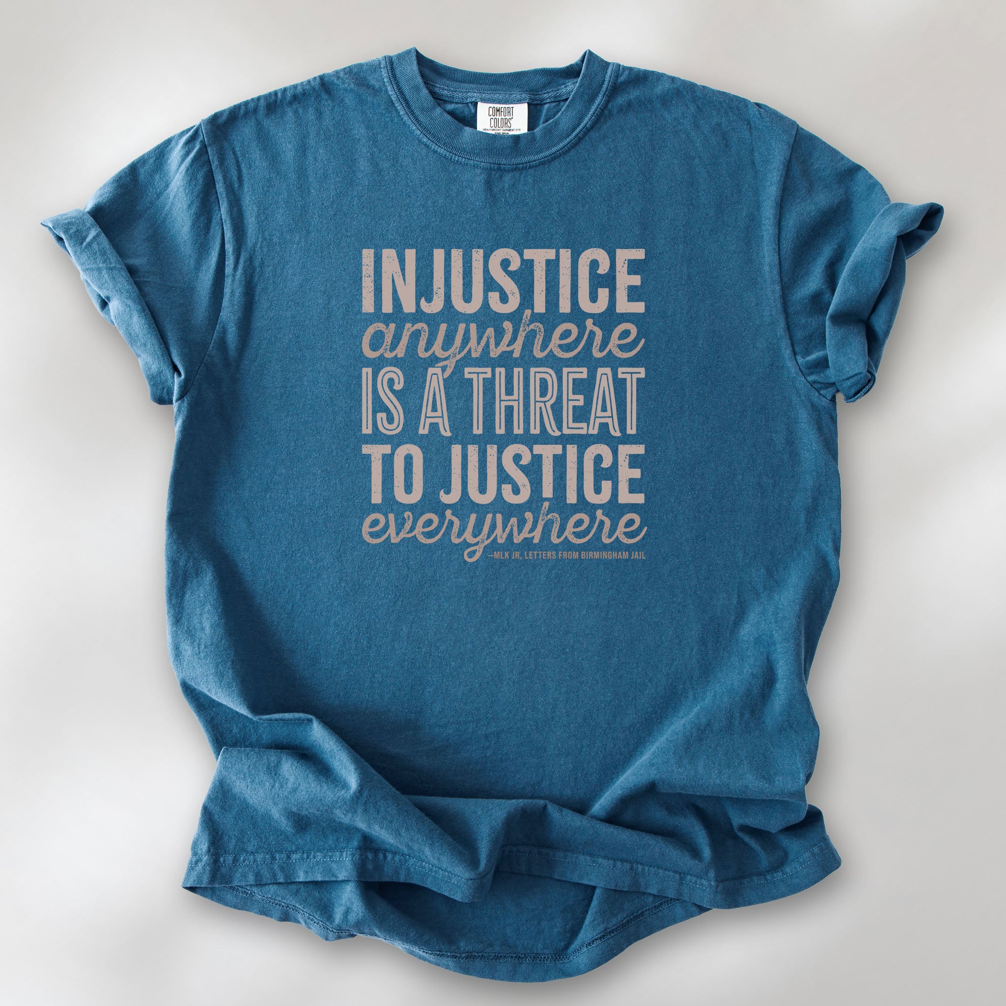 Midnight t-shirt with bold text reading “Injustice anywhere is a threat to justice everywhere” quote from Martin Luther King Jr, MLK Jr, Letters from Birmingham jail — civil rights protest apparel for activists.