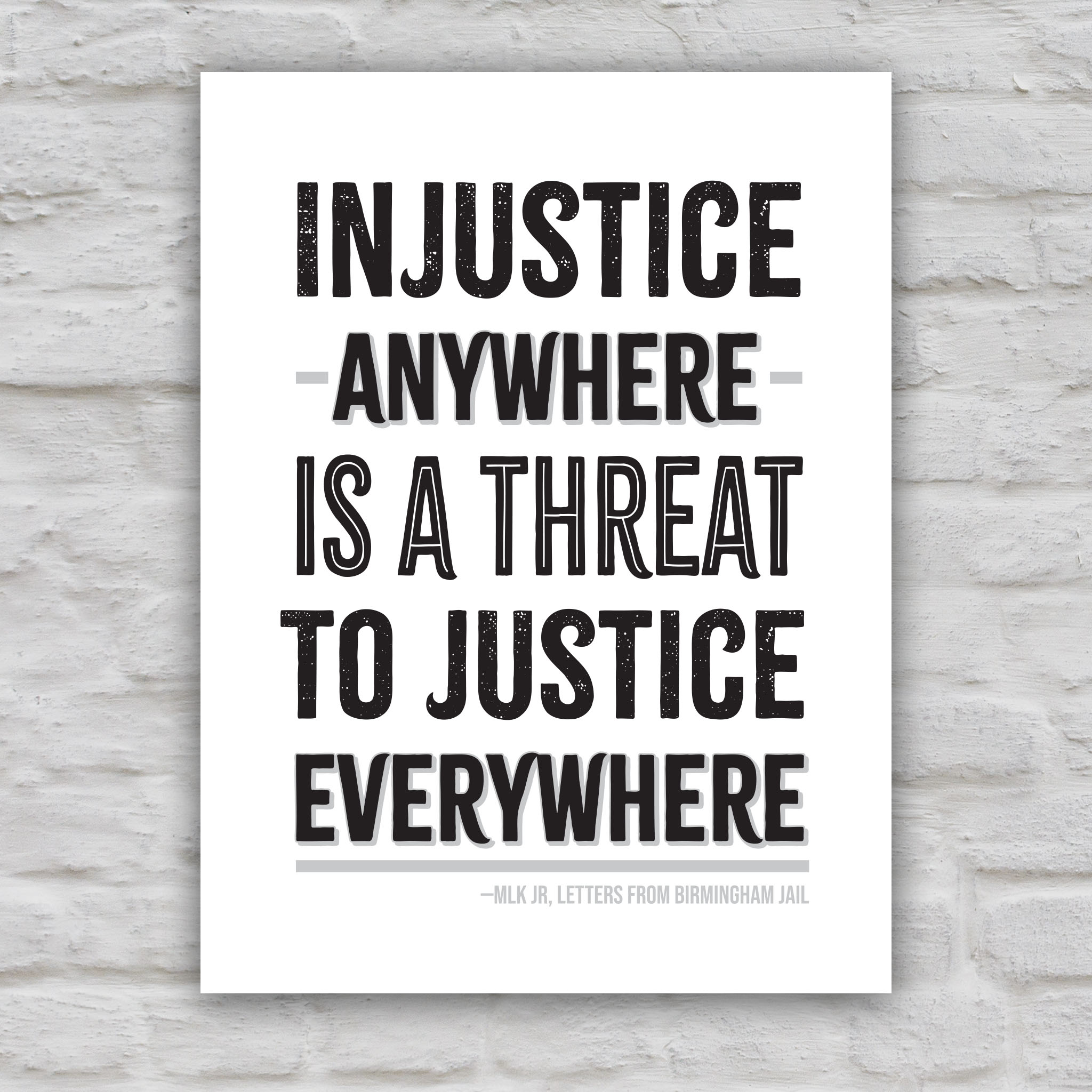 Black and white version of protest sign with quote from Martin Luther King Jr that reads "injustice anywhere is a threat to justice everywhere" in bold black distressed text.