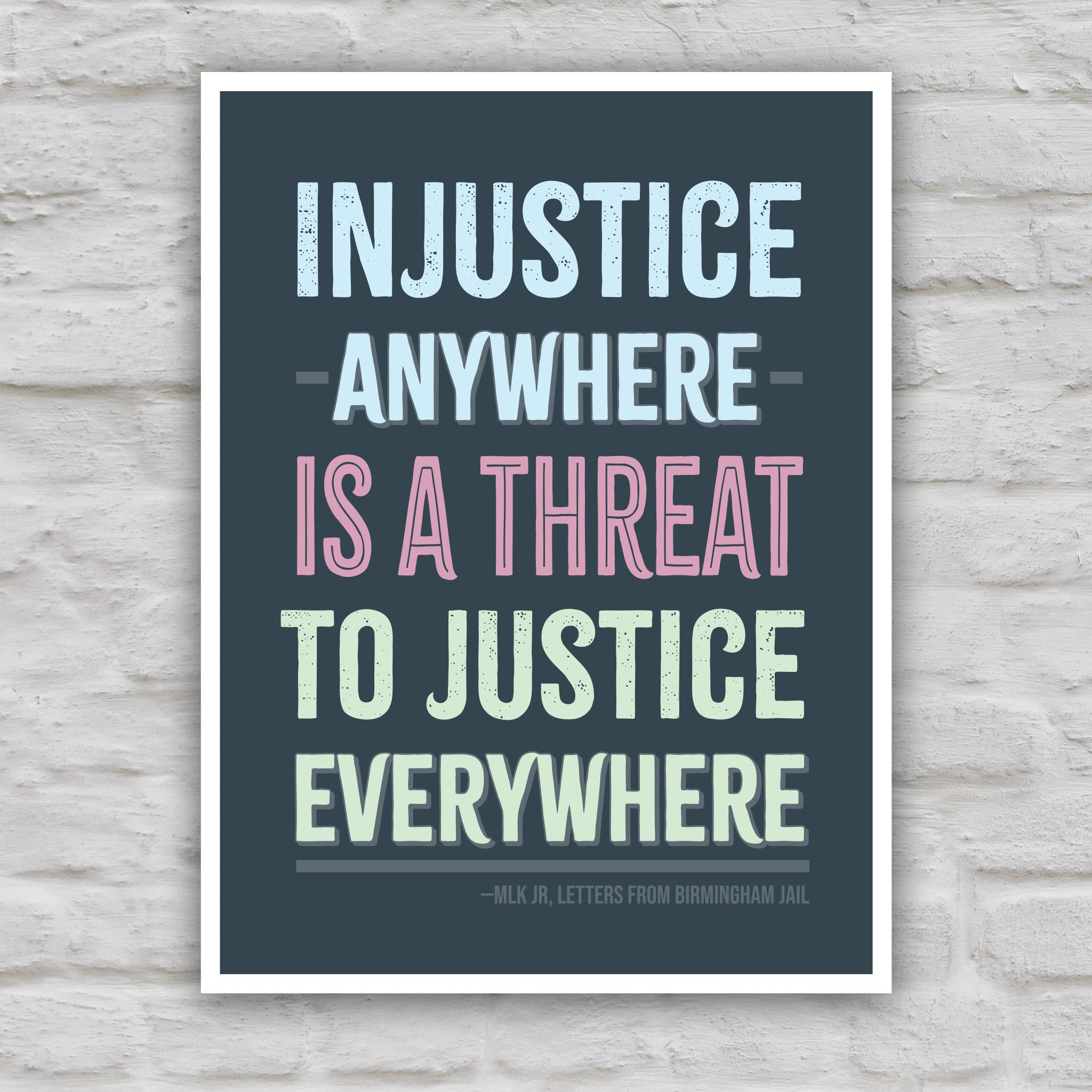 Color version of protest sign with quote from Martin Luther King Jr that reads "injustice anywhere is a threat to justice everywhere" in colorful bold distressed text.