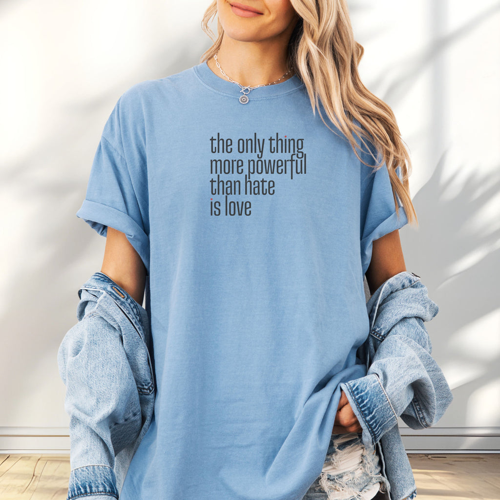 Female model wearing washed denim t-shirt with a stylized text block reading “the only thing more powerful than hate is love."