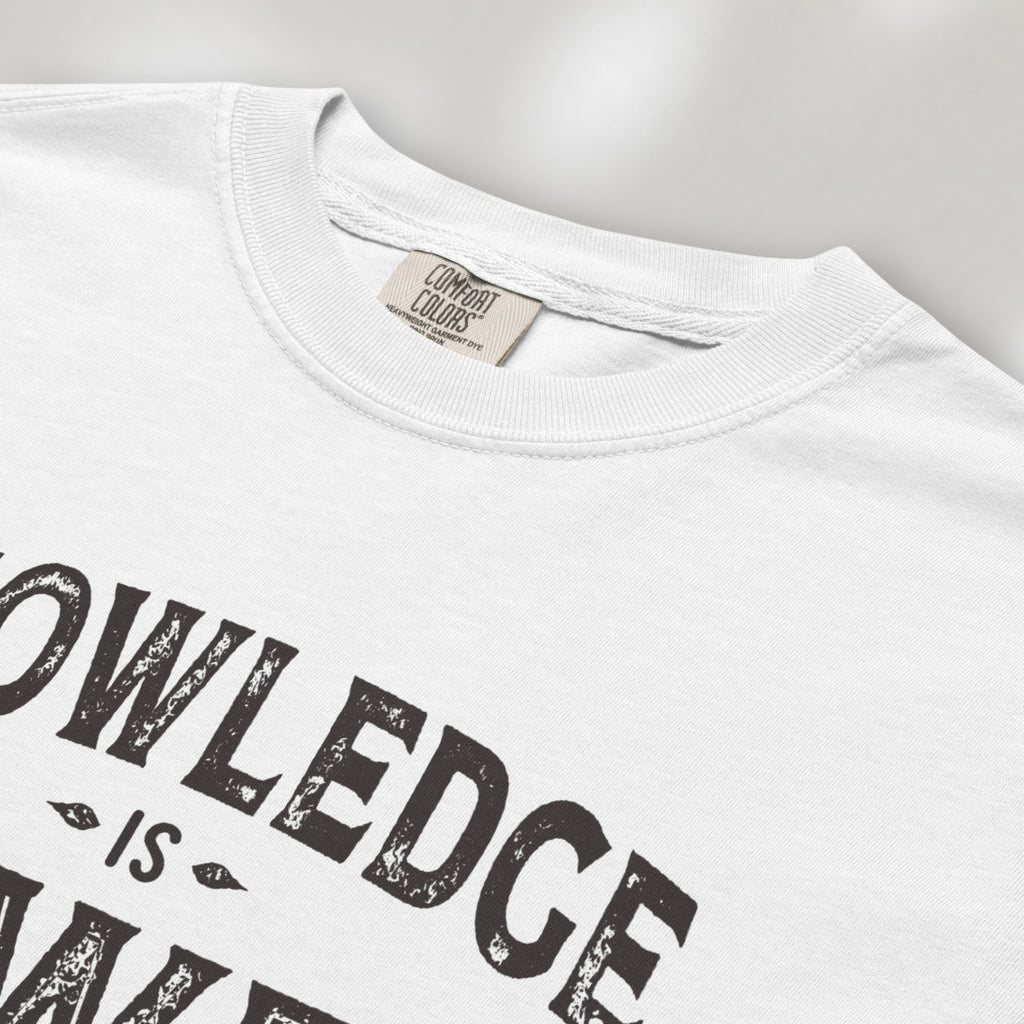 Closeup detail of white t-shirt with vintage style typography reading “Knowledge Is Power – Keep Learning."