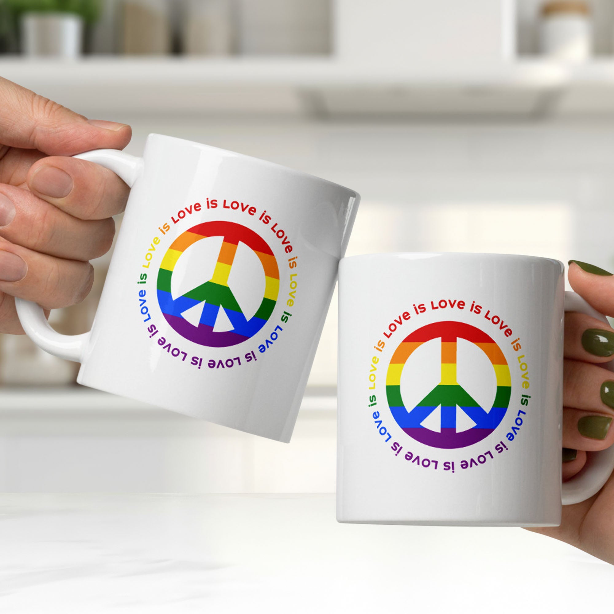 Two people holding ceramic coffee mug with a peace sign in the colors of the LGBTQ+ flag, surrounded by repeated "love is love" text. They are clinking the mugs together, showing graphic on both sides of the mug.