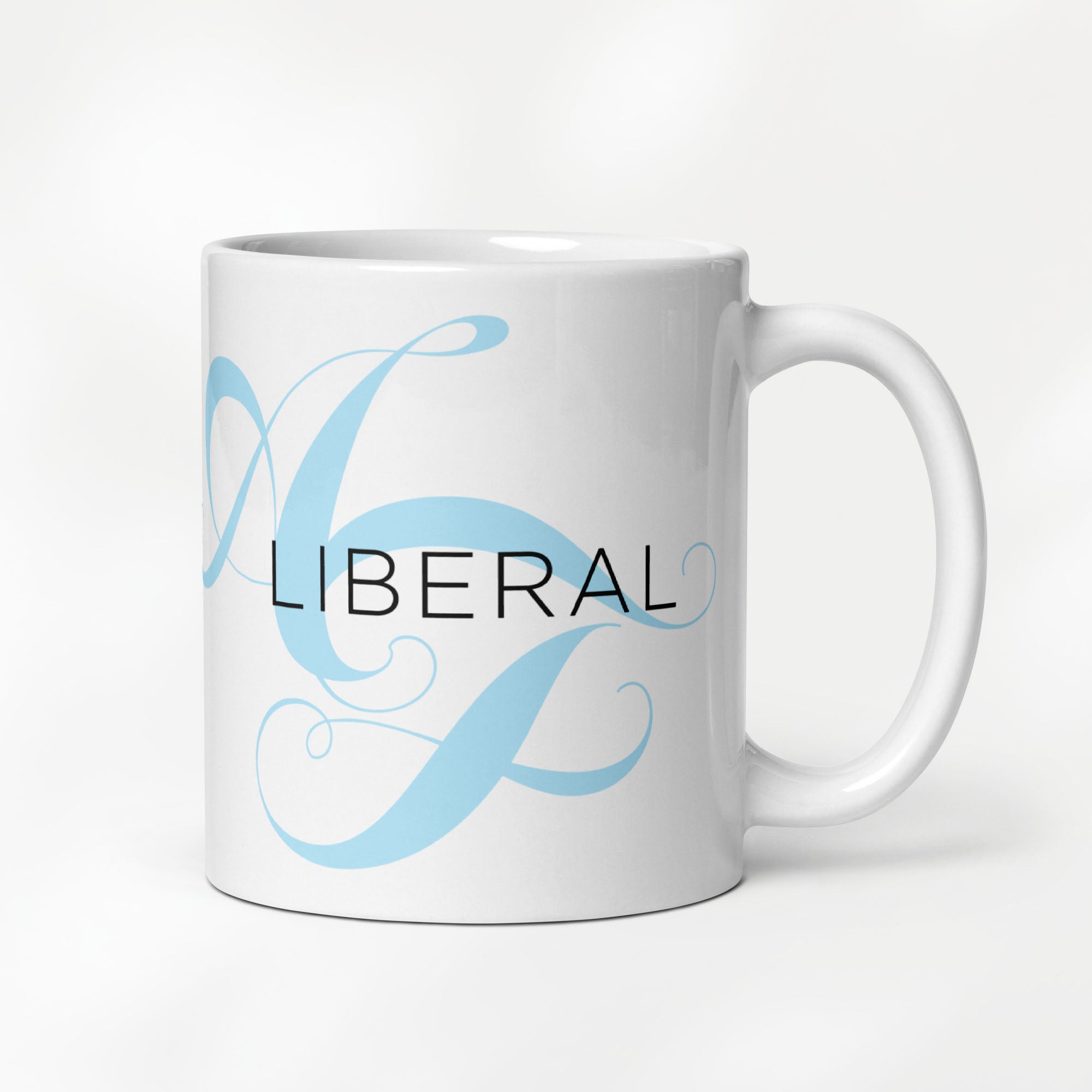 11 ounce white ceramic mug with the word “Liberal” in black text and a subtle light bright blue script design of the letters A and F in the background.