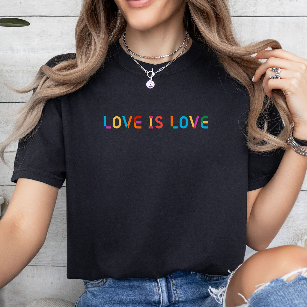 Female model wearing black t-shirt with rainbow “love is love” text designed in the Gilbert font.