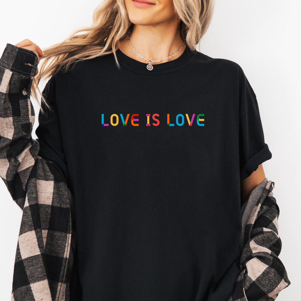 Female model wearing black t-shirt with rainbow “love is love” text designed in the Gilbert font.
