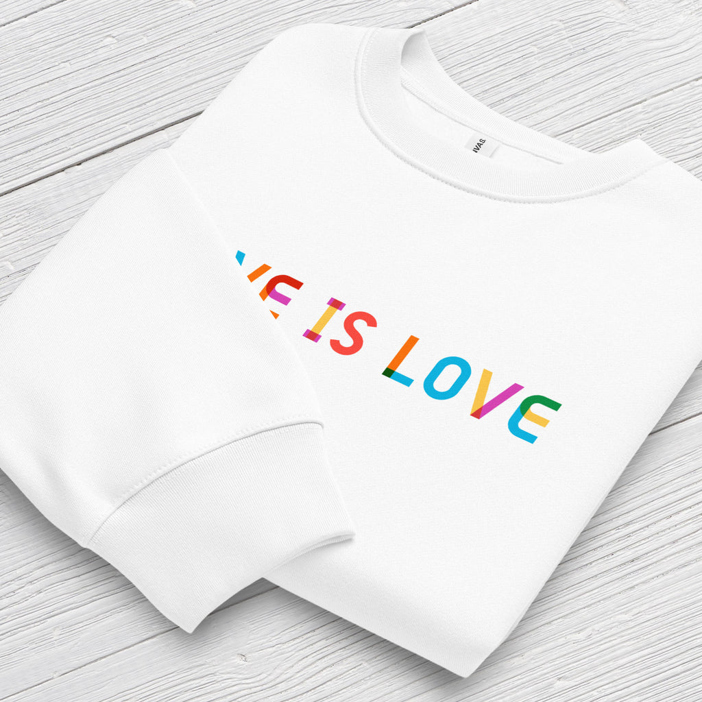 Folded white Bella+Canvas crewneck sweatshirt with rainbow “love is love” text designed in the Gilbert font, showing cuff detail.