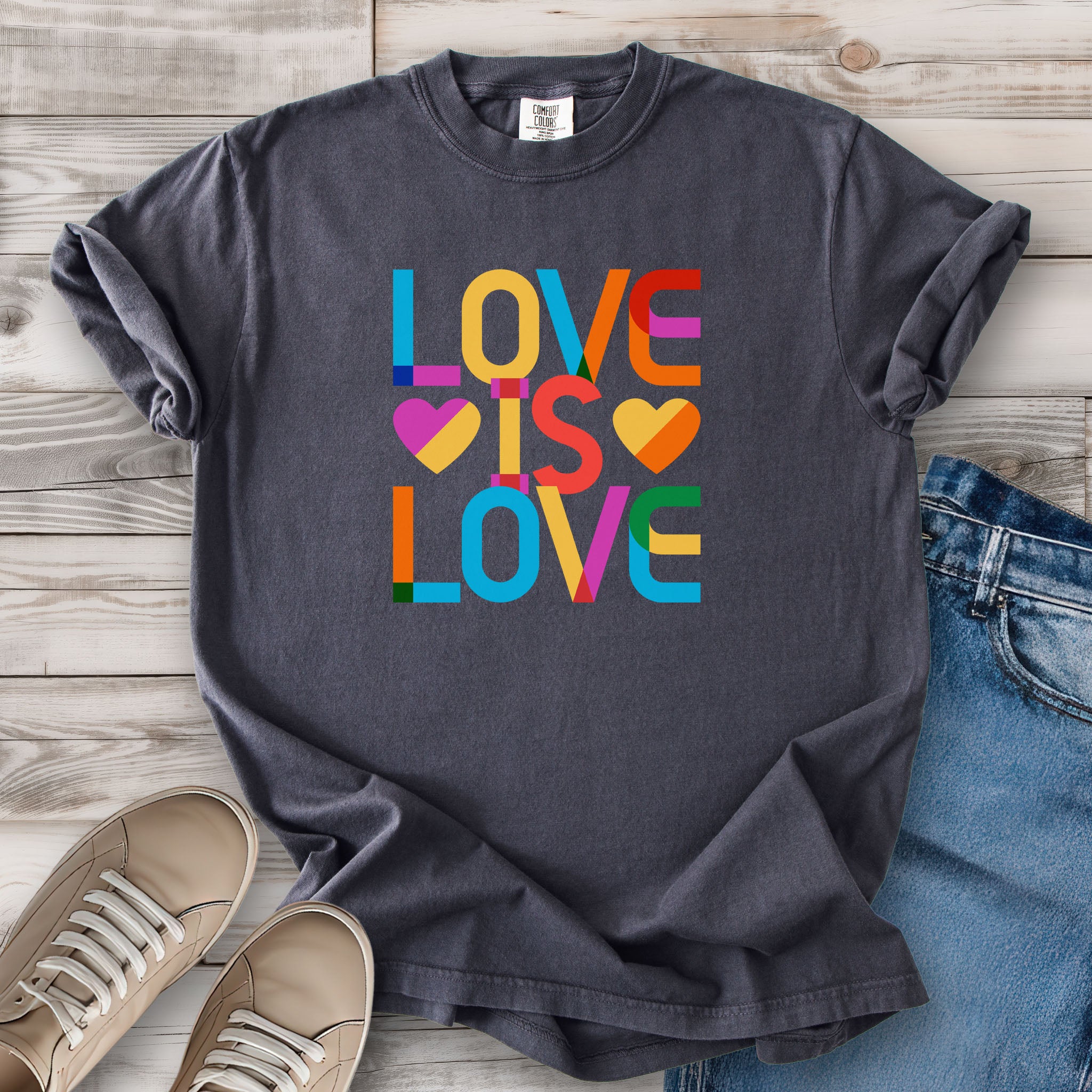 Graphite grey t-shirt with rainbow “love is love” text designed in the Gilbert font.