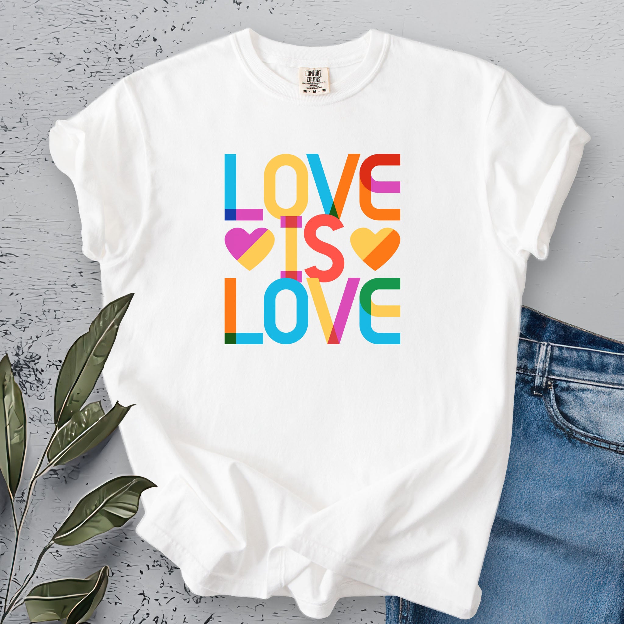 White t-shirt with rainbow “love is love” stacked styled text.