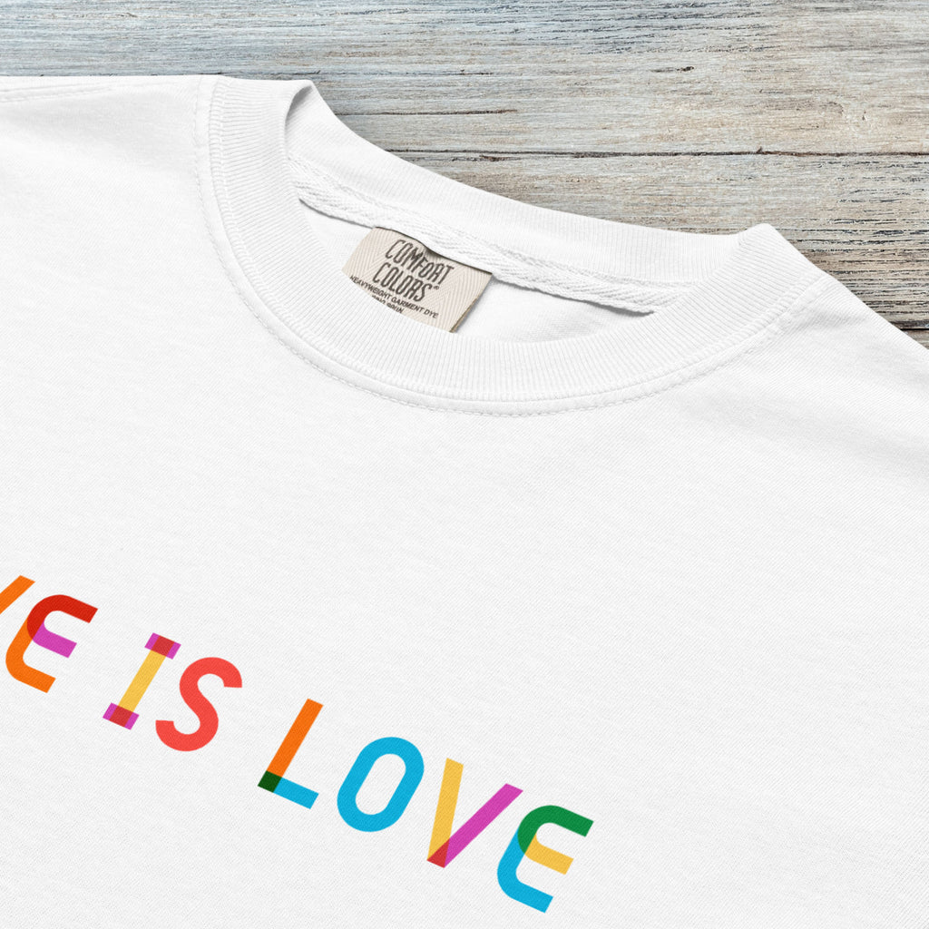 Closeup detail of white t-shirt with rainbow “love is love” text in a single line.