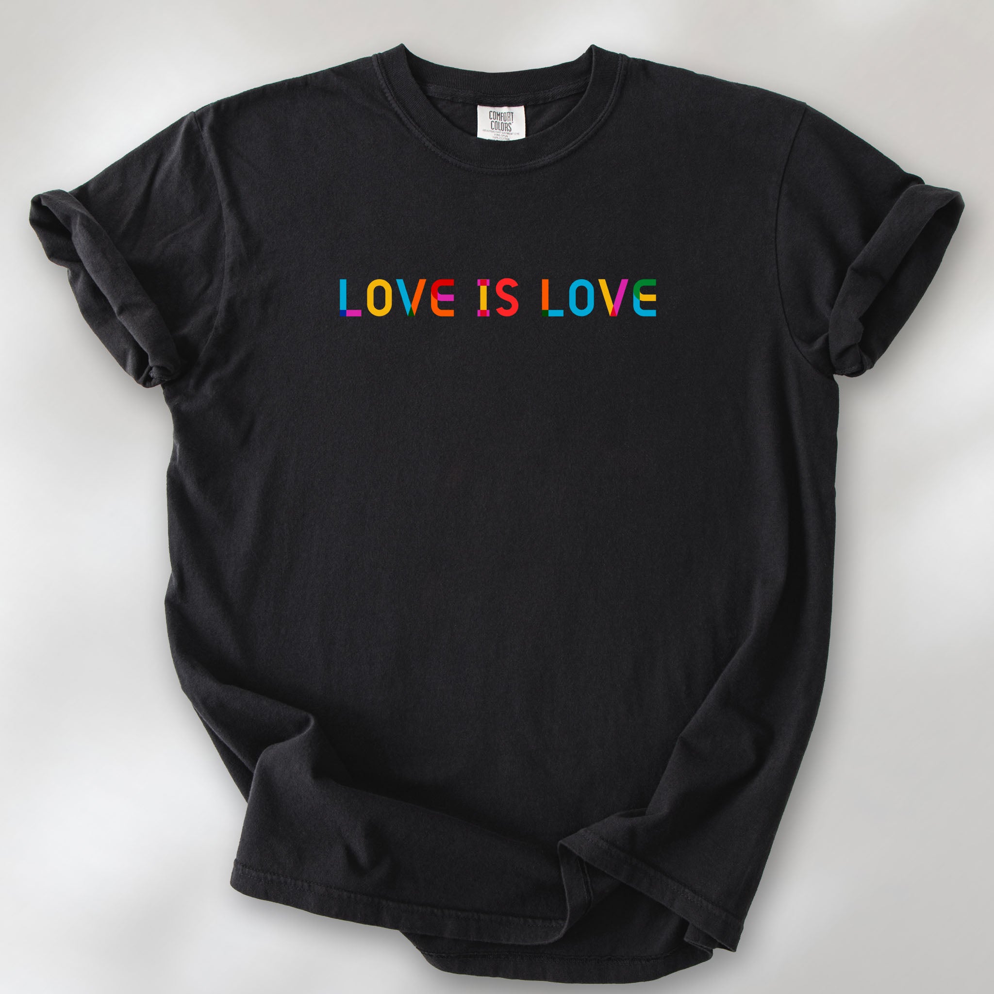 Black t-shirt with rainbow “love is love” text in a single line.