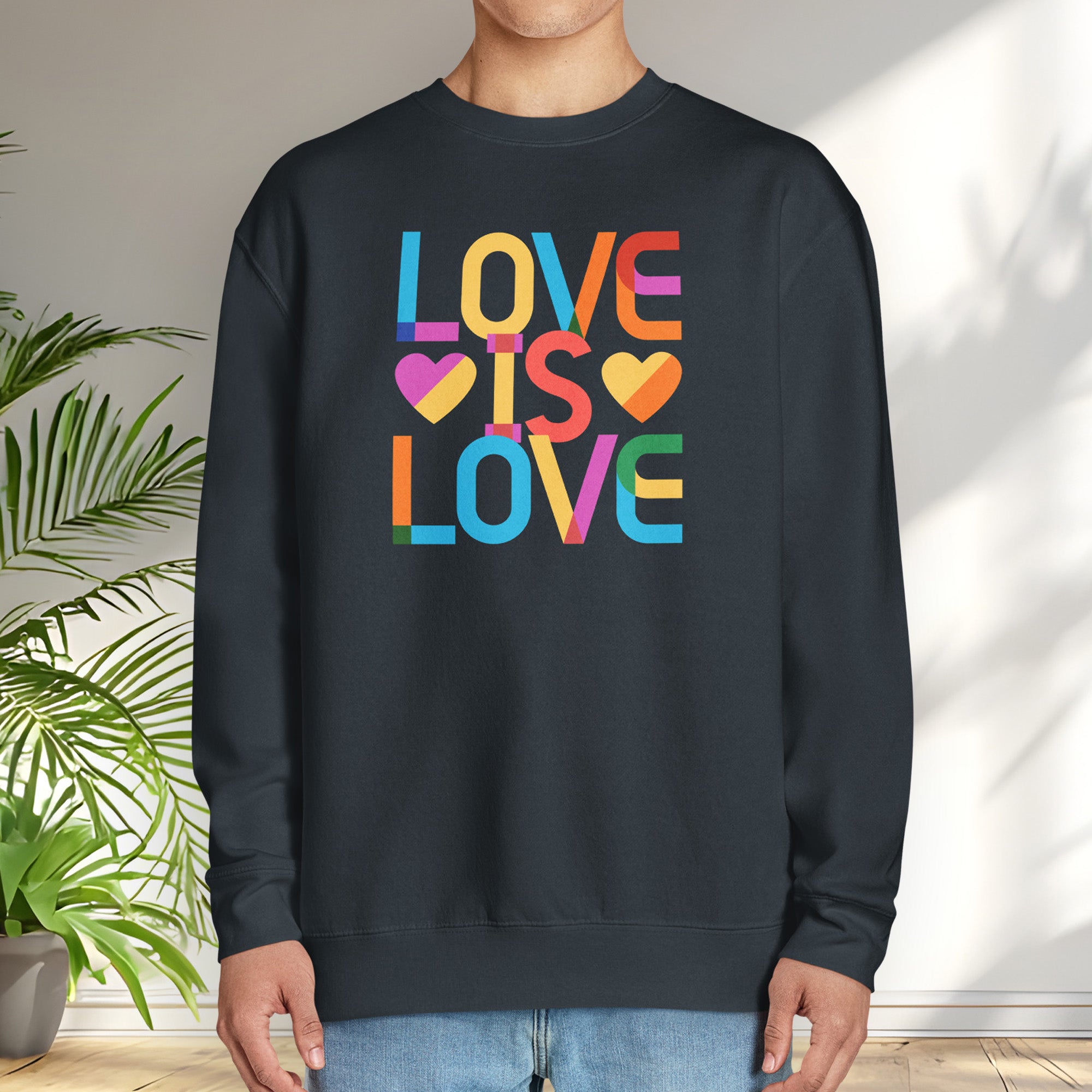 Male model wearing navy sweatshirt with rainbow “love is love” text designed in the Gilbert font.