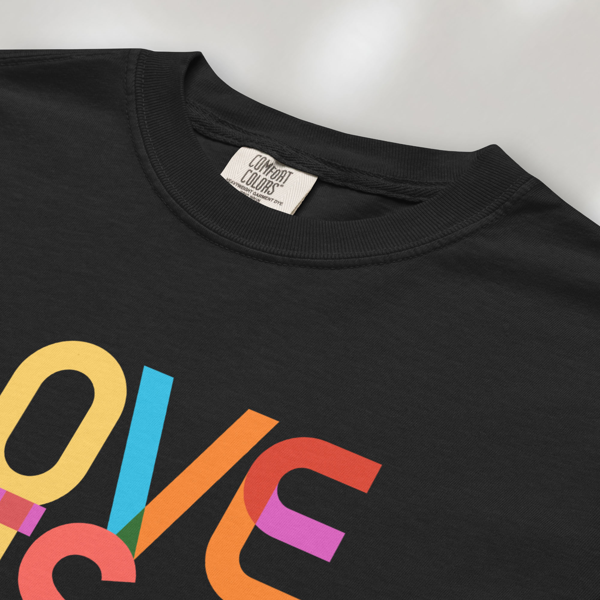 Closeup of black t-shirt with rainbow “love is love” text block.