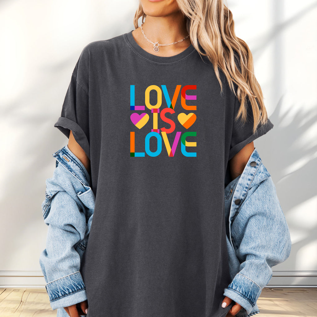 Female model wearing oversized pepper t-shirt with rainbow “love is love” text block.