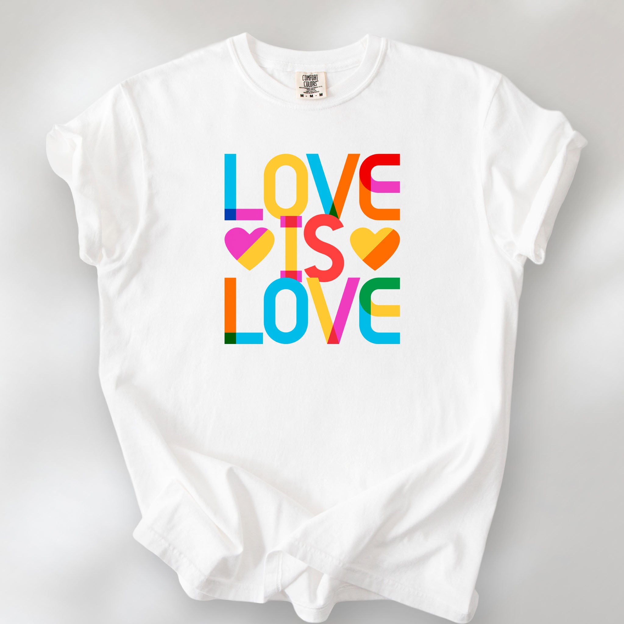 White t-shirt with rainbow “love is love” text block.