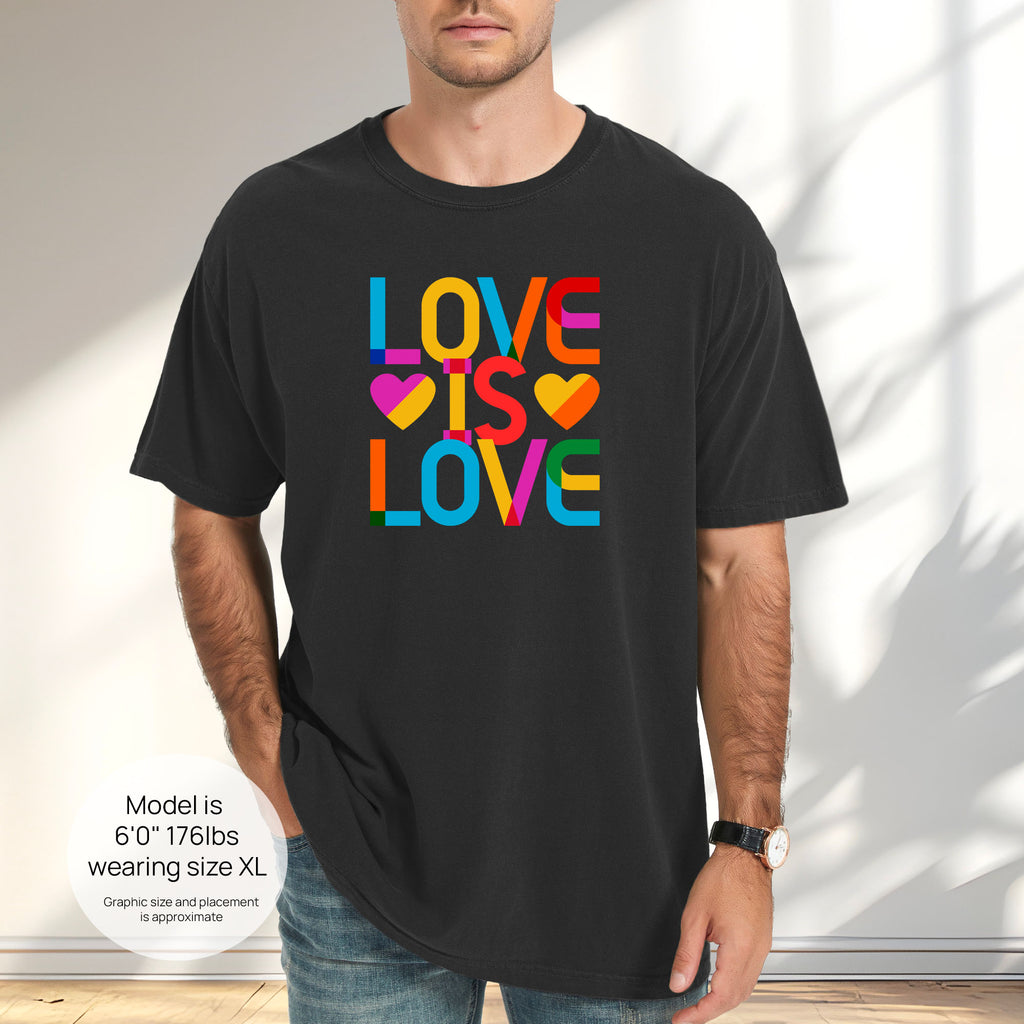 Male model wearing black t-shirt with rainbow “love is love” text block. Includes size and fit information for the model who is 6 feet 0 inches, 176 pounds, and wearing a size XL shirt.
