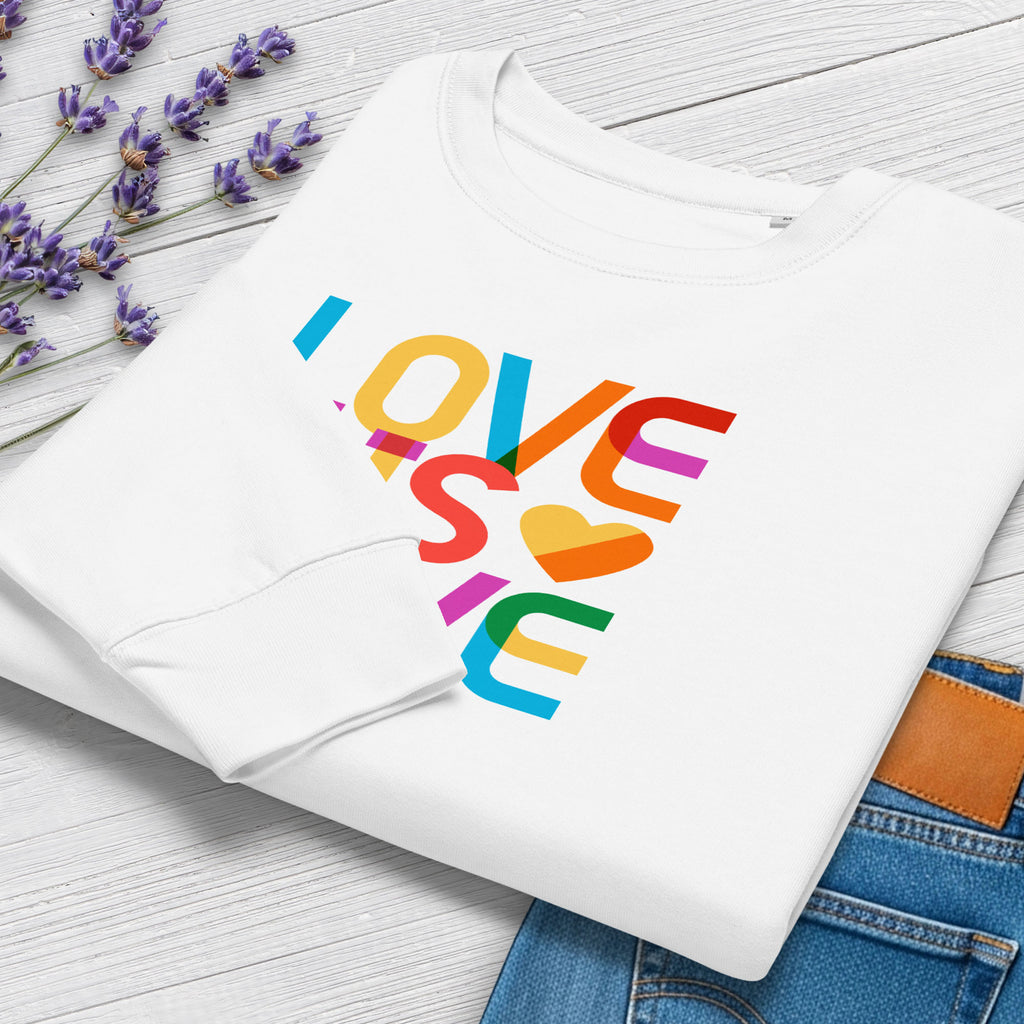Folded white women's sweatshirt with rainbow “love is love” text designed in the Gilbert font, showing cuff detail.