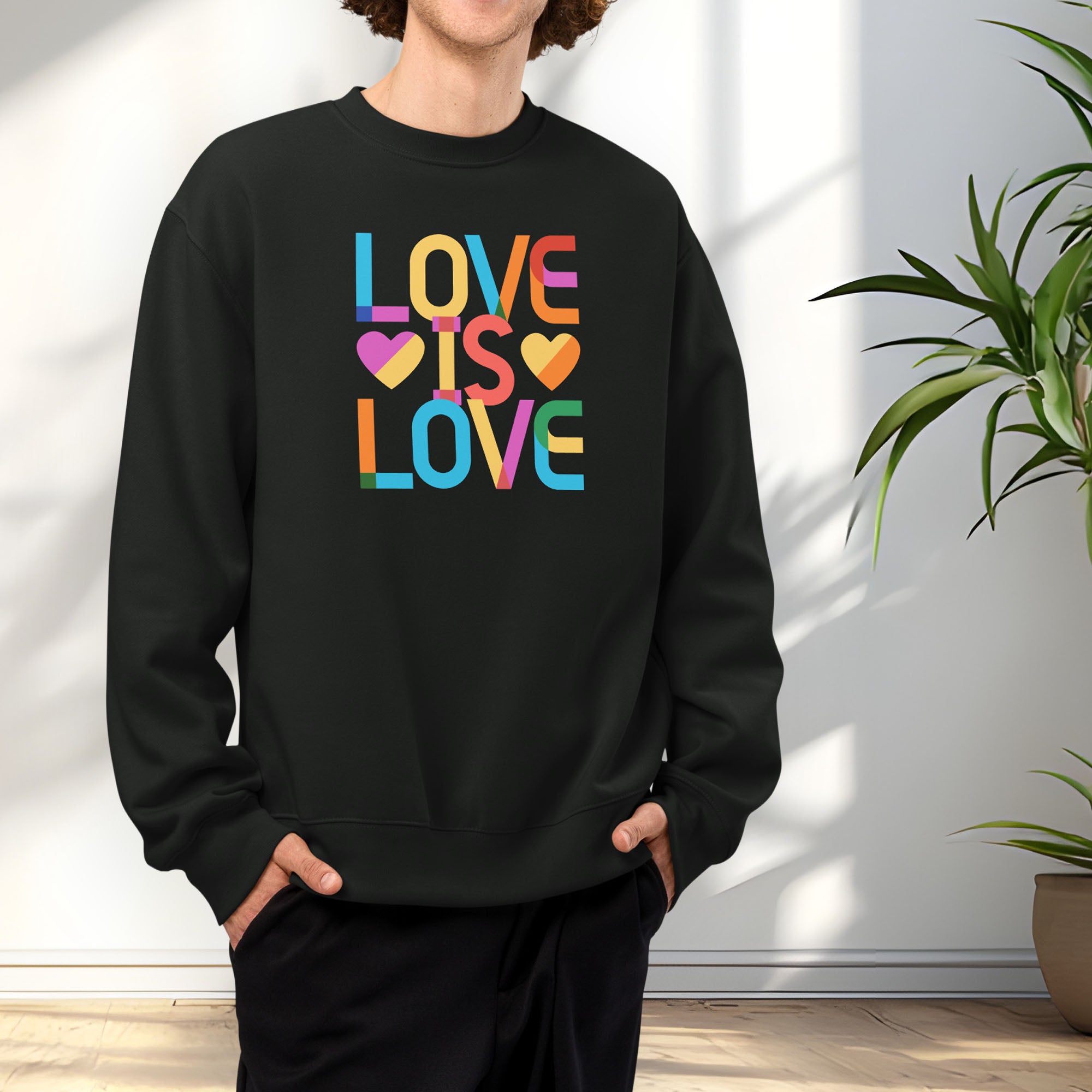 Male model wearing black t-shirt with rainbow “love is love” text designed in the Gilbert font.