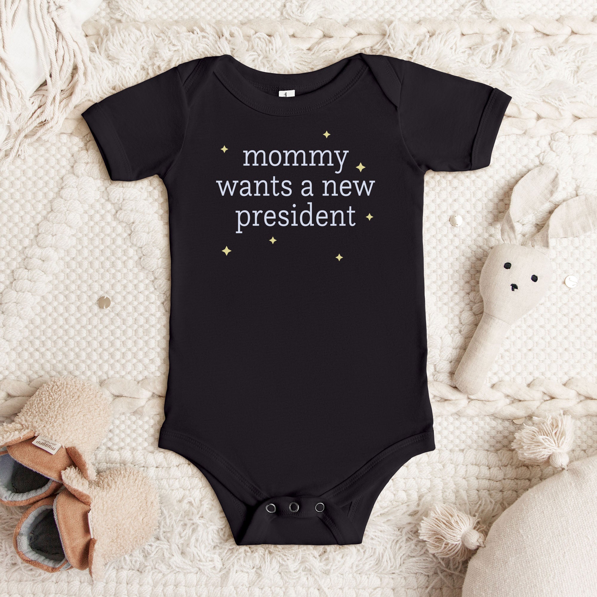 Black baby short sleeve one piece with light text reading “mommy wants a new president."