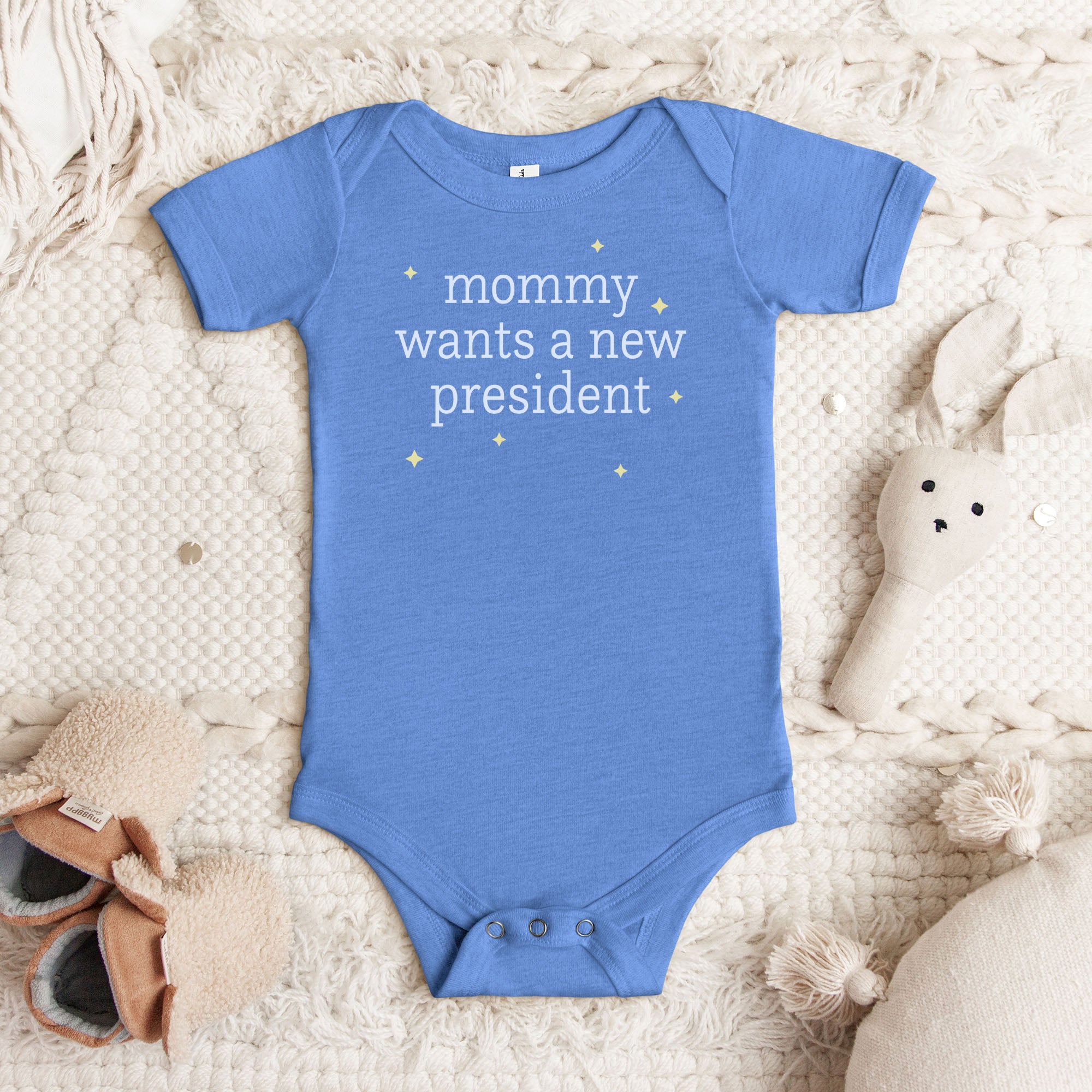 Columbia blue heather baby short sleeve one piece with light text reading “mommy wants a new president."