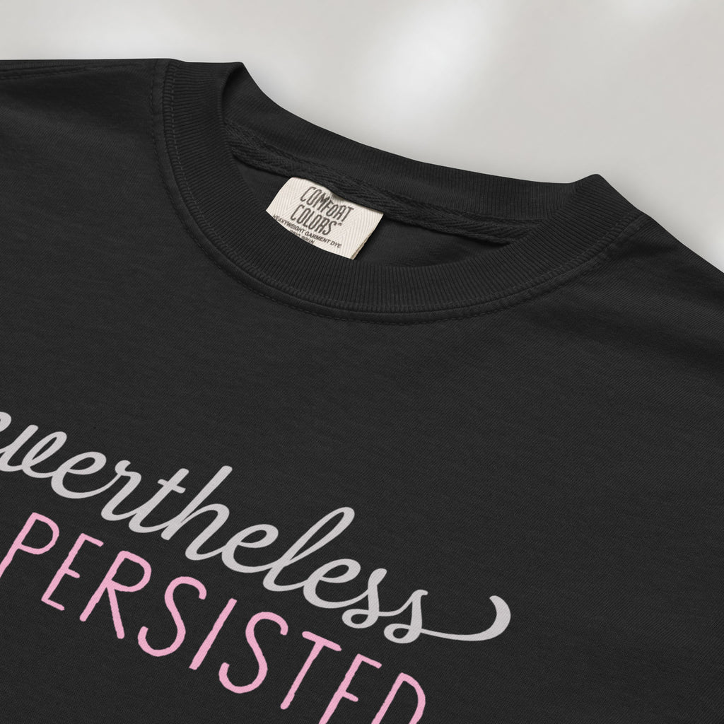 Closeup detail of black t-shirt with stylized text that reads "nevertheless she persisted."